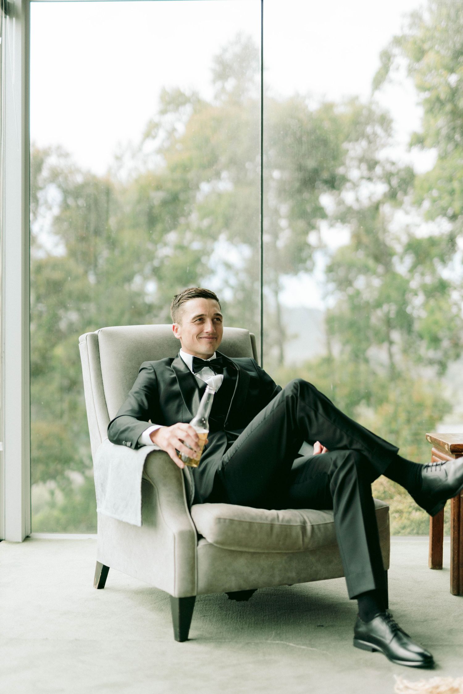 A series of photos showing someone relaxing in a modern white armchair by floor-to-ceiling windows.
