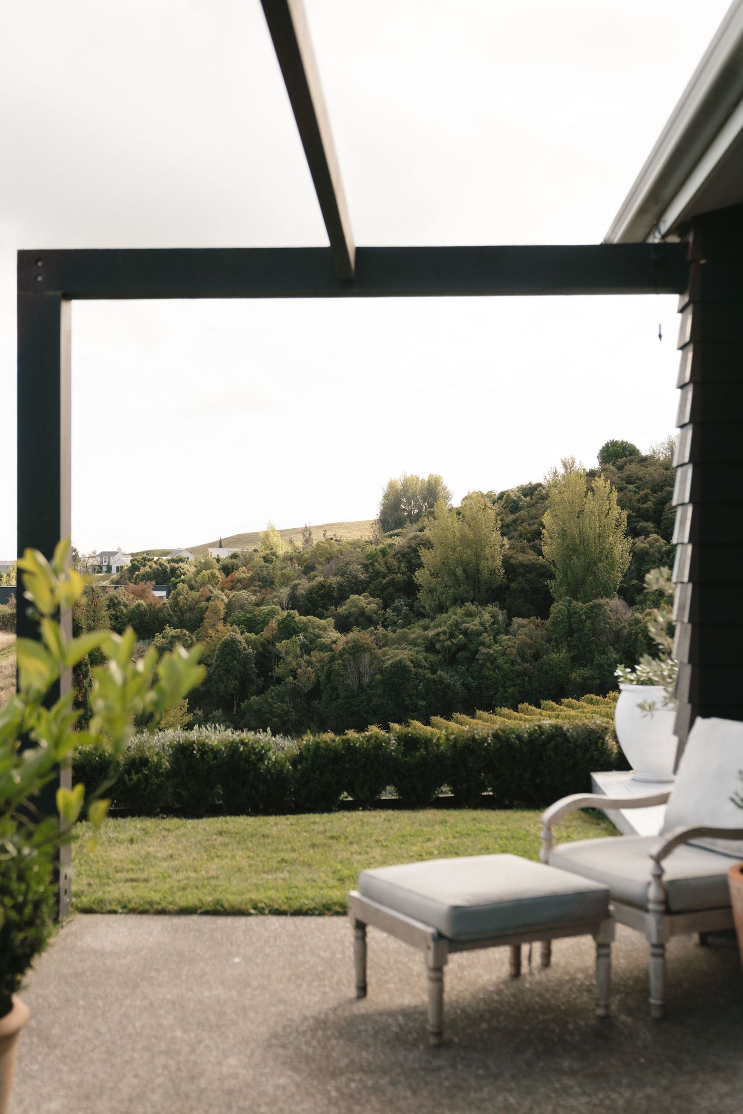 Tranquil outdoor seating area overlooking expansive vineyard and rolling hills in wine country.