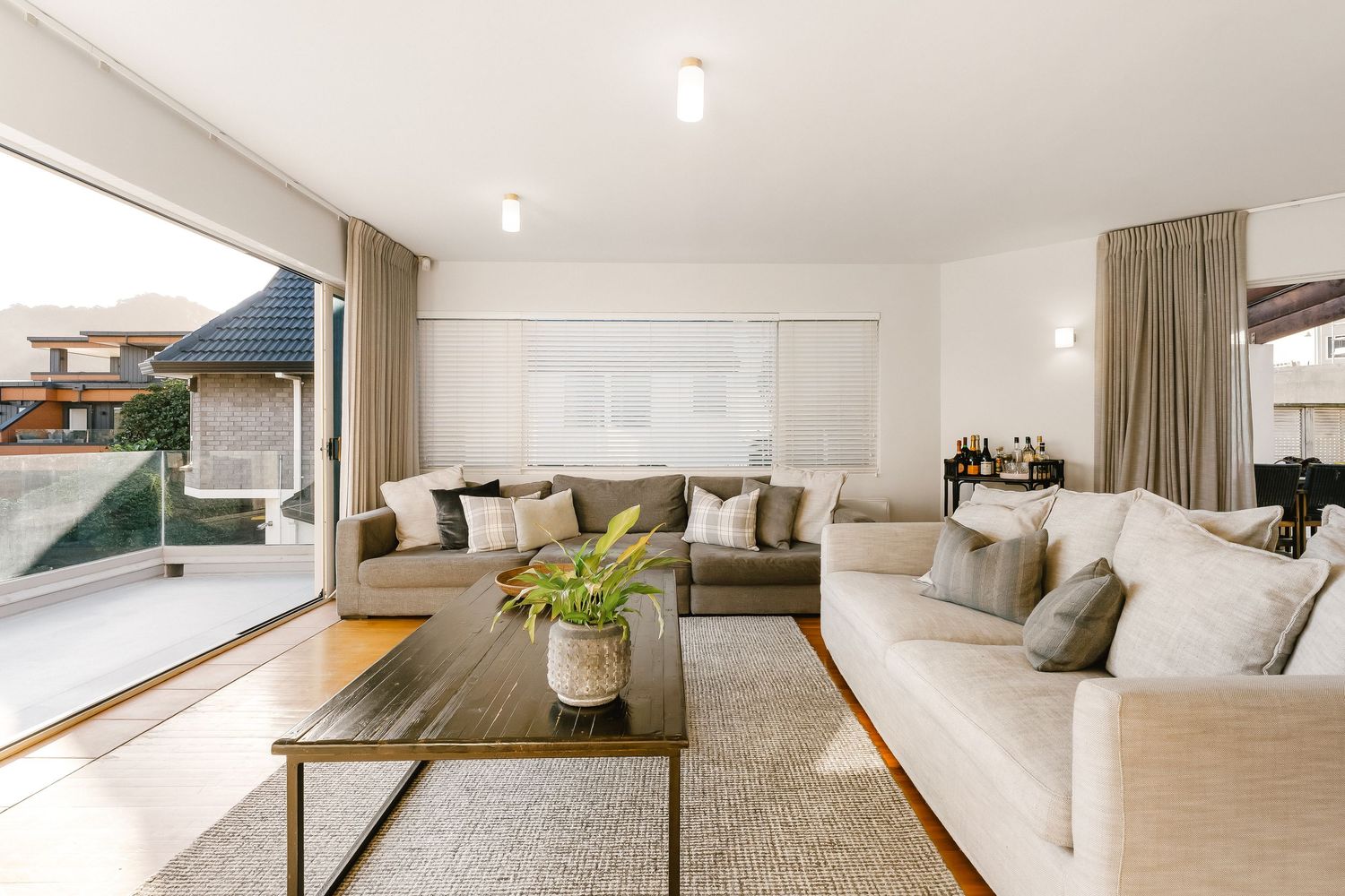 Spacious open concept living area with white walls and contemporary furnishings.