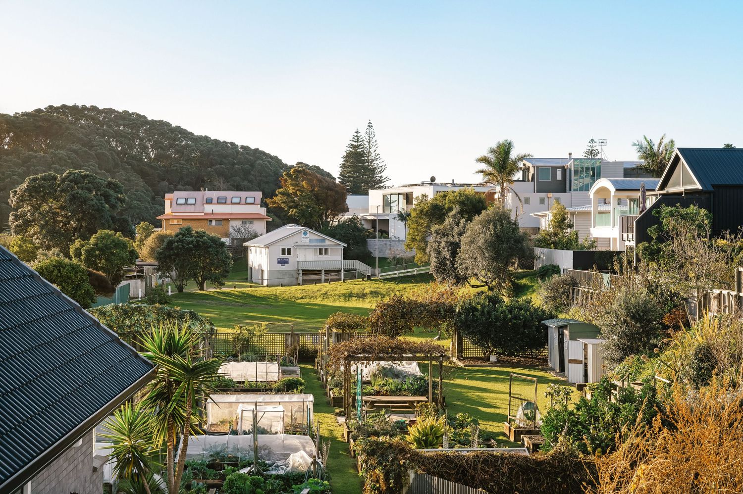 Panoramic view of hillside homes and properties overlooking a scenic coastal landscape.