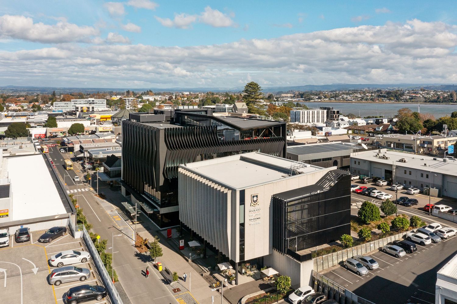 Aerial view of commercial buildings and parking lots in an urban business district on a sunny day.