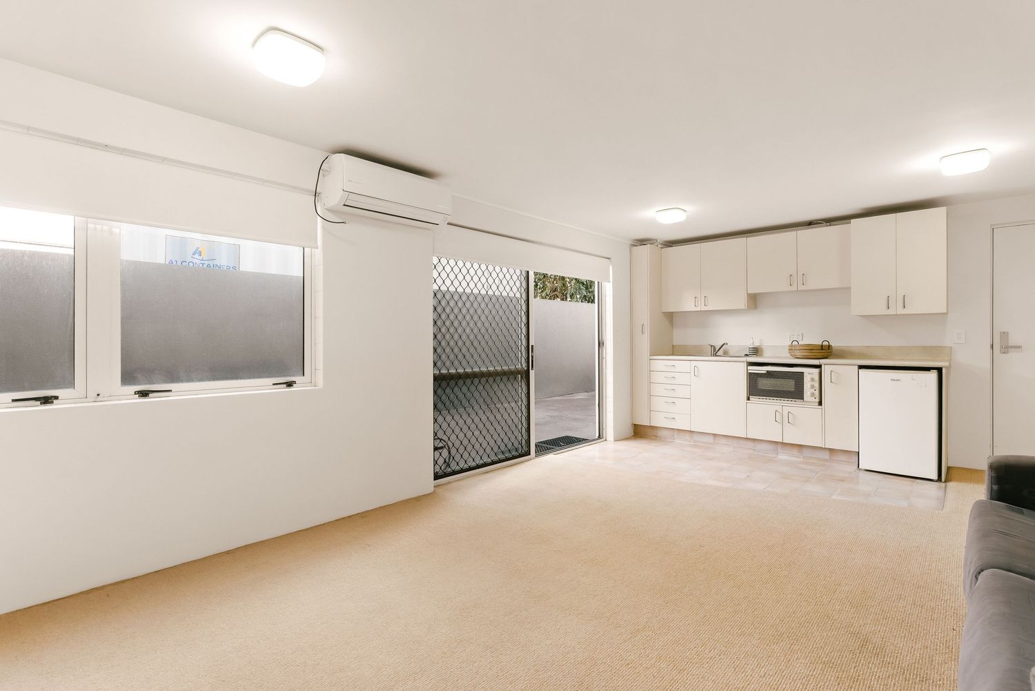 Spacious interior room with white walls, recessed lighting and clean minimalist design elements.