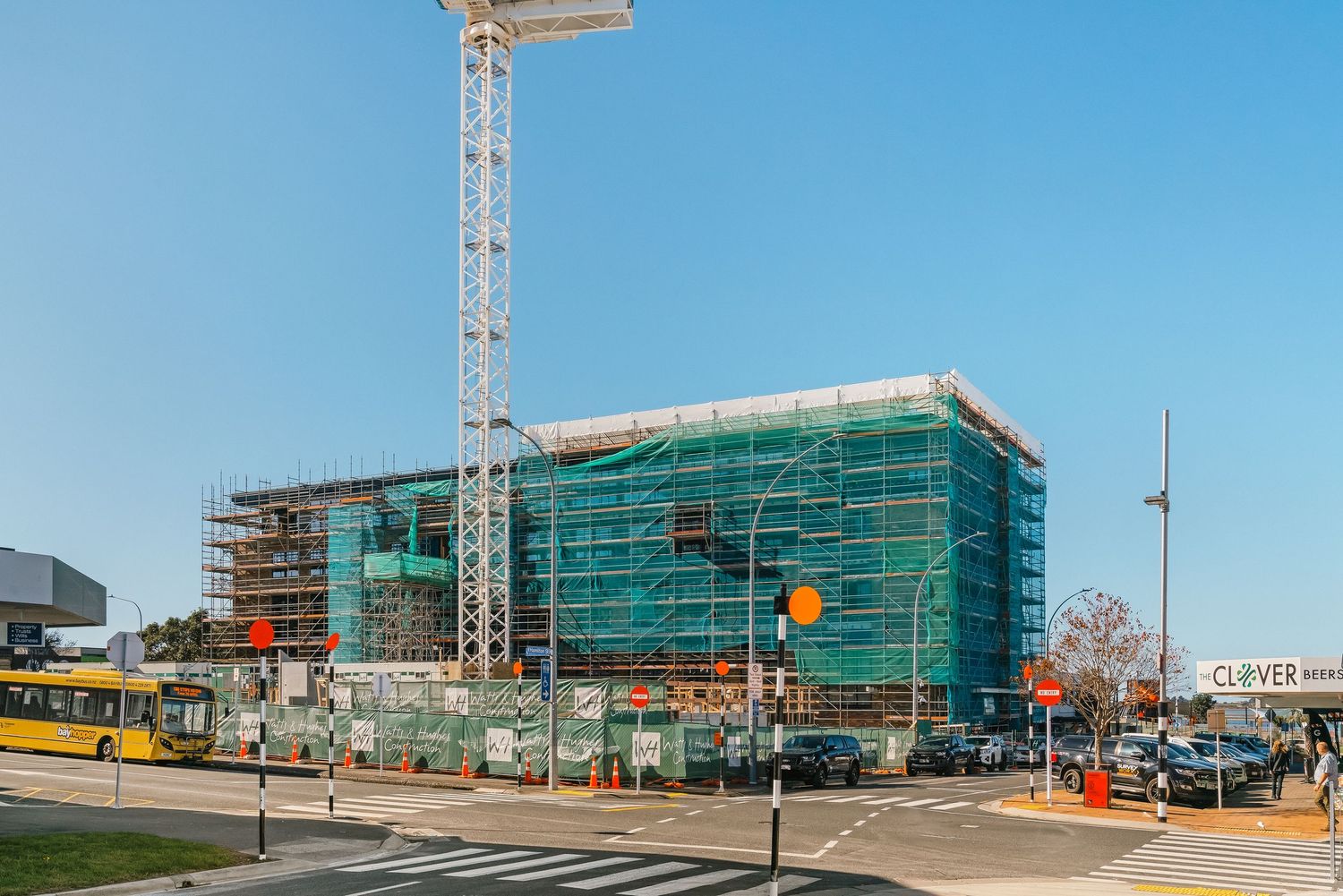 Construction site showing scaffolding and crane work on a large commercial building development.