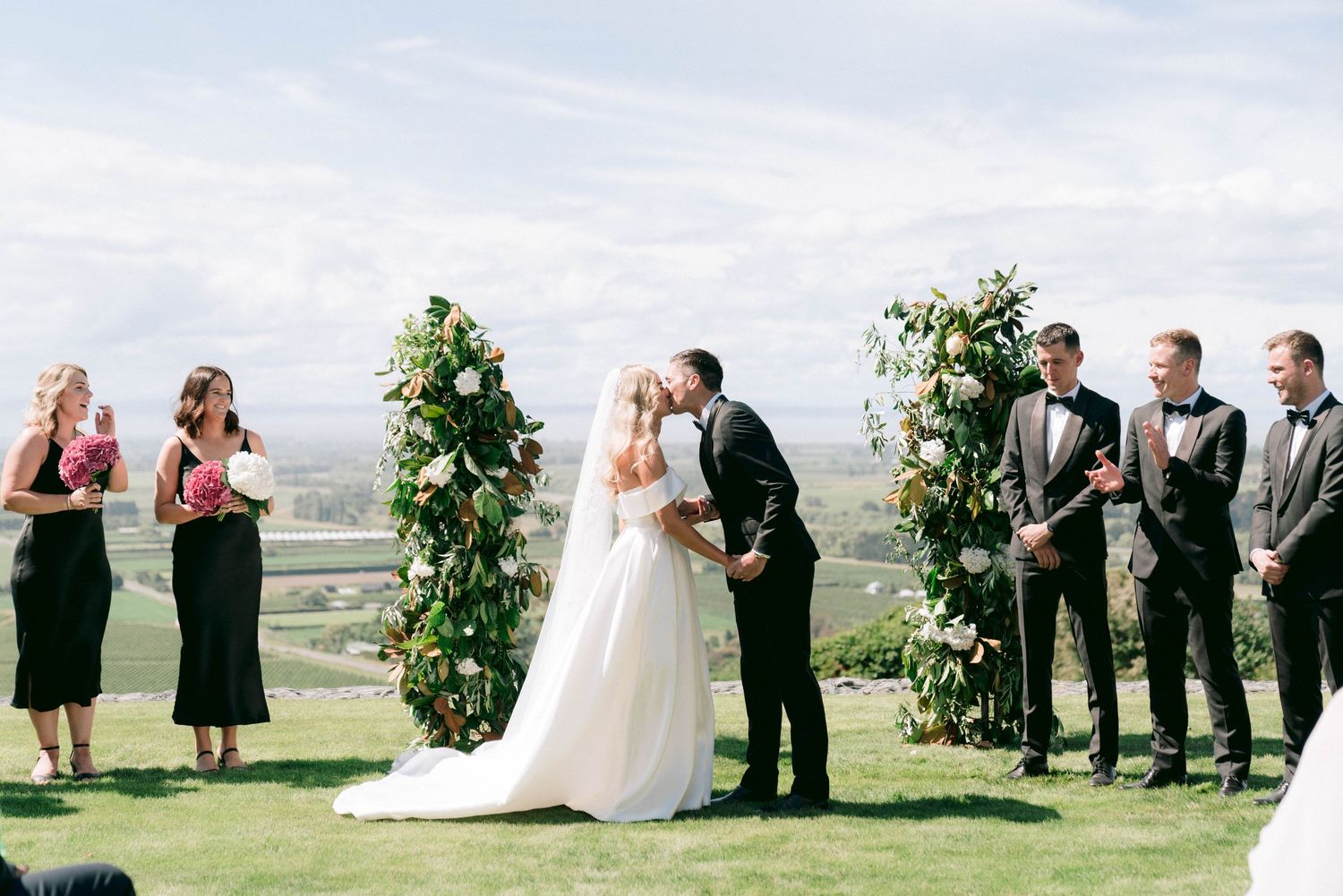 Outdoor wedding ceremony setup with mountain backdrop and floral arrangements.