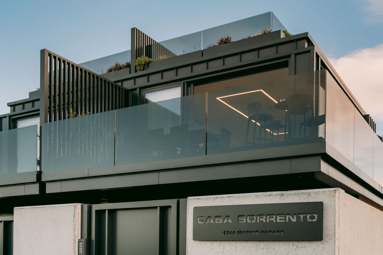 Modern two-story commercial building with glass balustrade and sleek architectural details.