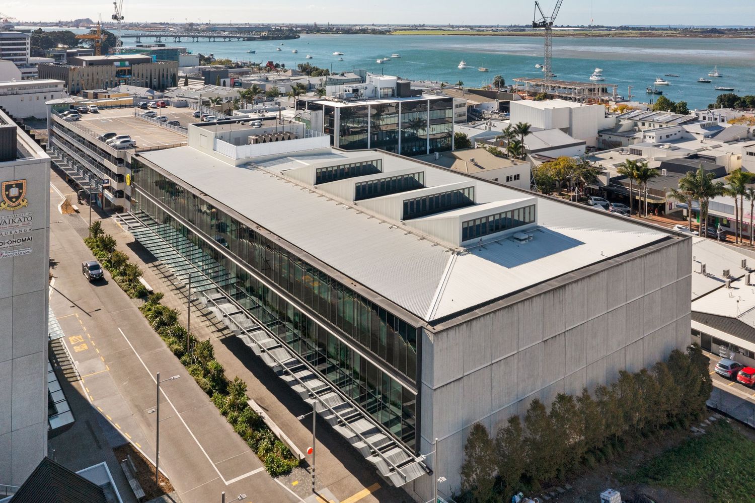 Bird's eye view of commercial buildings and parking structures along coastal development.