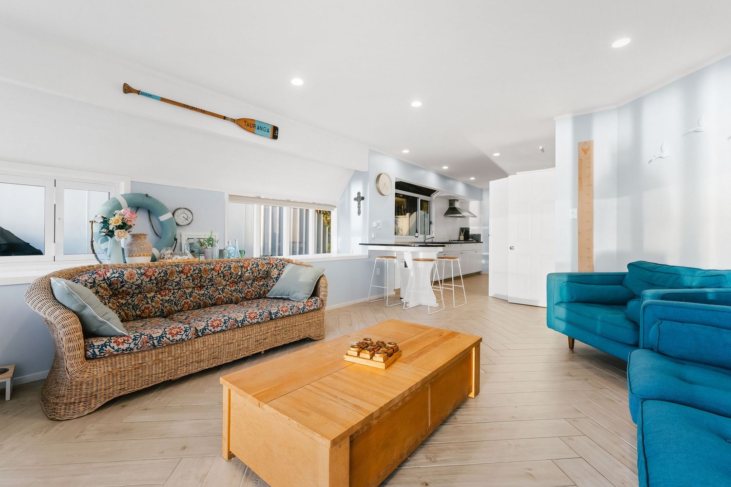 Sleek modern living area with wooden storage bench and blue velvet sectional sofa.