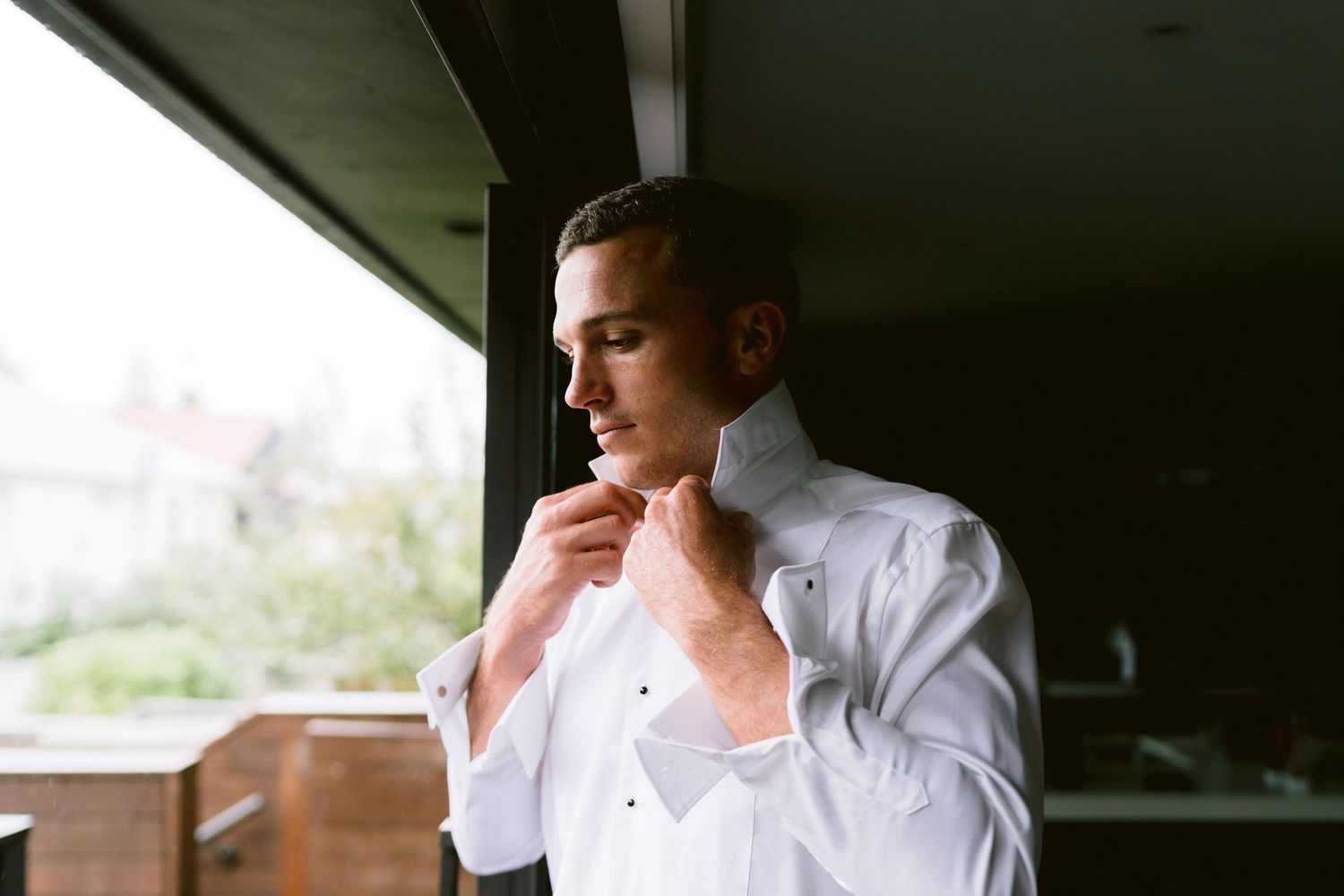 Chef in white uniform tasting food while working in a restaurant kitchen.