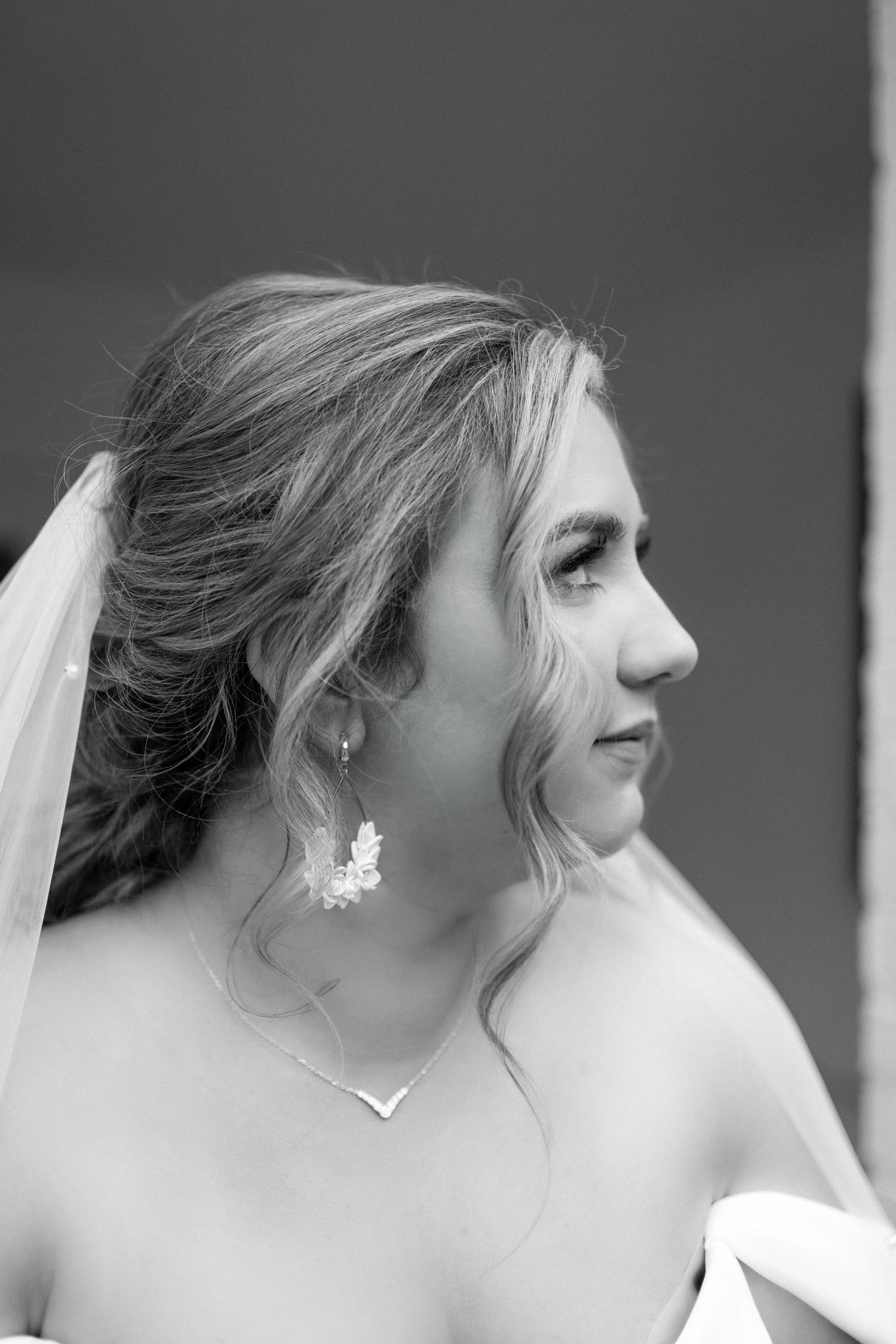 Close-up side profile shots captured in black and white showing delicate bridal jewelry and veil details.