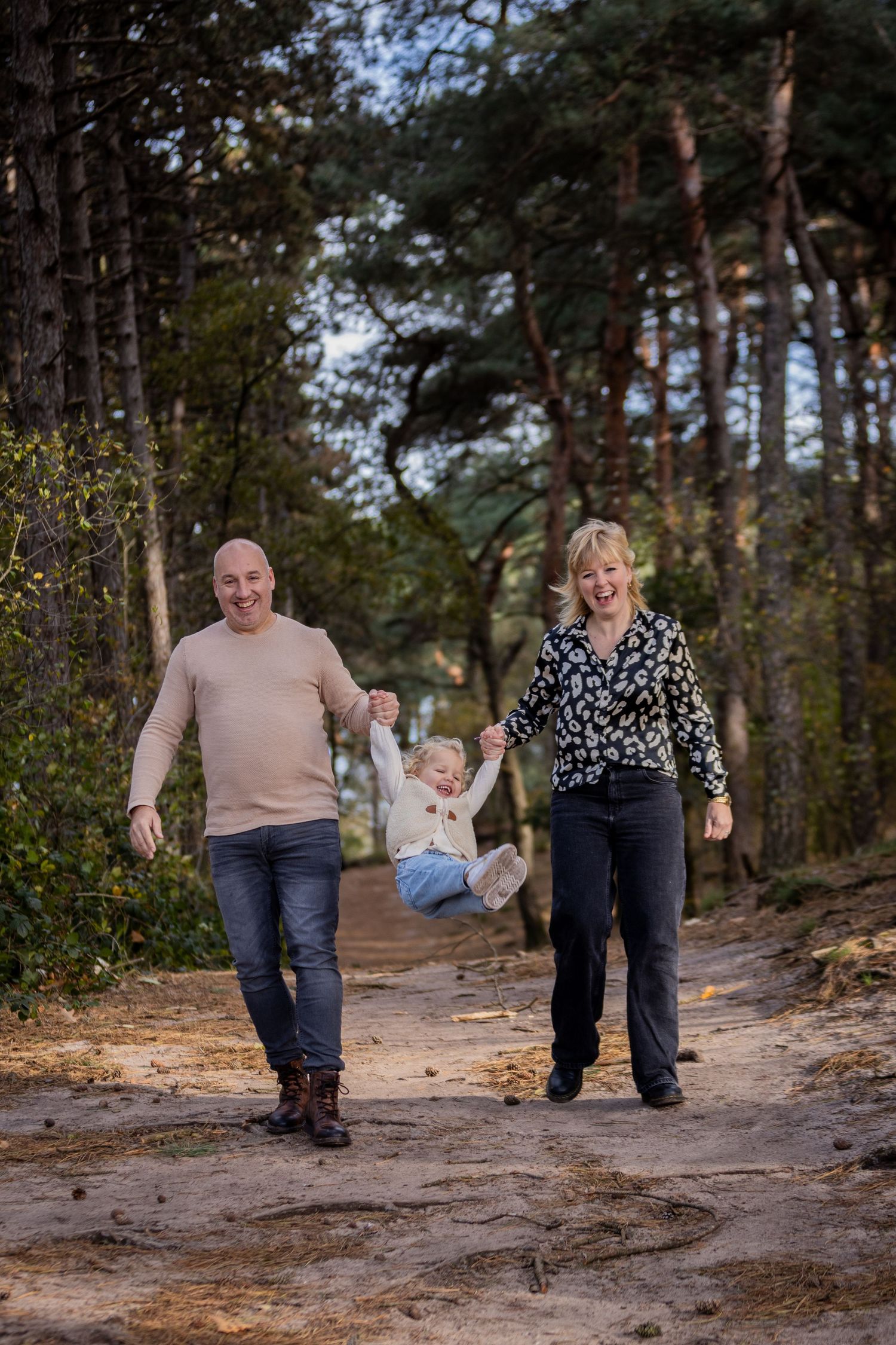 Family walking together on natural forest trail during autumn season.