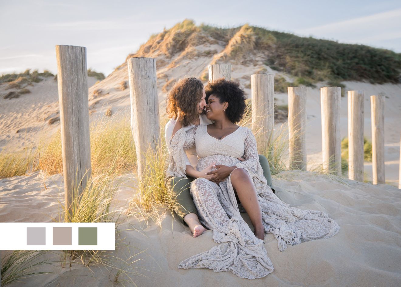 Two people sitting intimately among beach fence posts at golden hour.