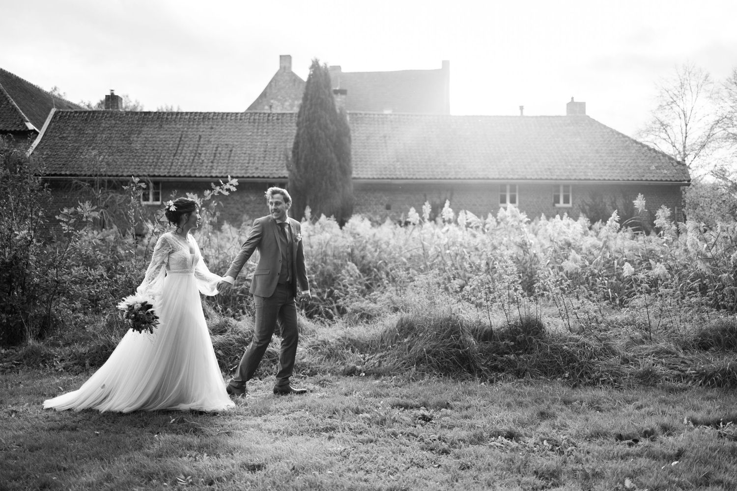 Black and white wedding photography in a rustic outdoor setting with countryside views.