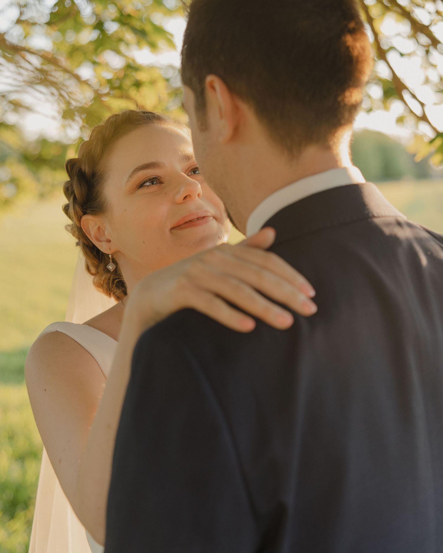 An intimate moment between newlyweds embracing in warm sunset light.