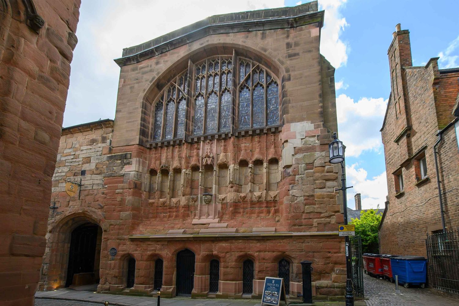 Historic sandstone entrance with Gothic arched windows and ornate stonework on an old Grade 1 listed building in Coventry.