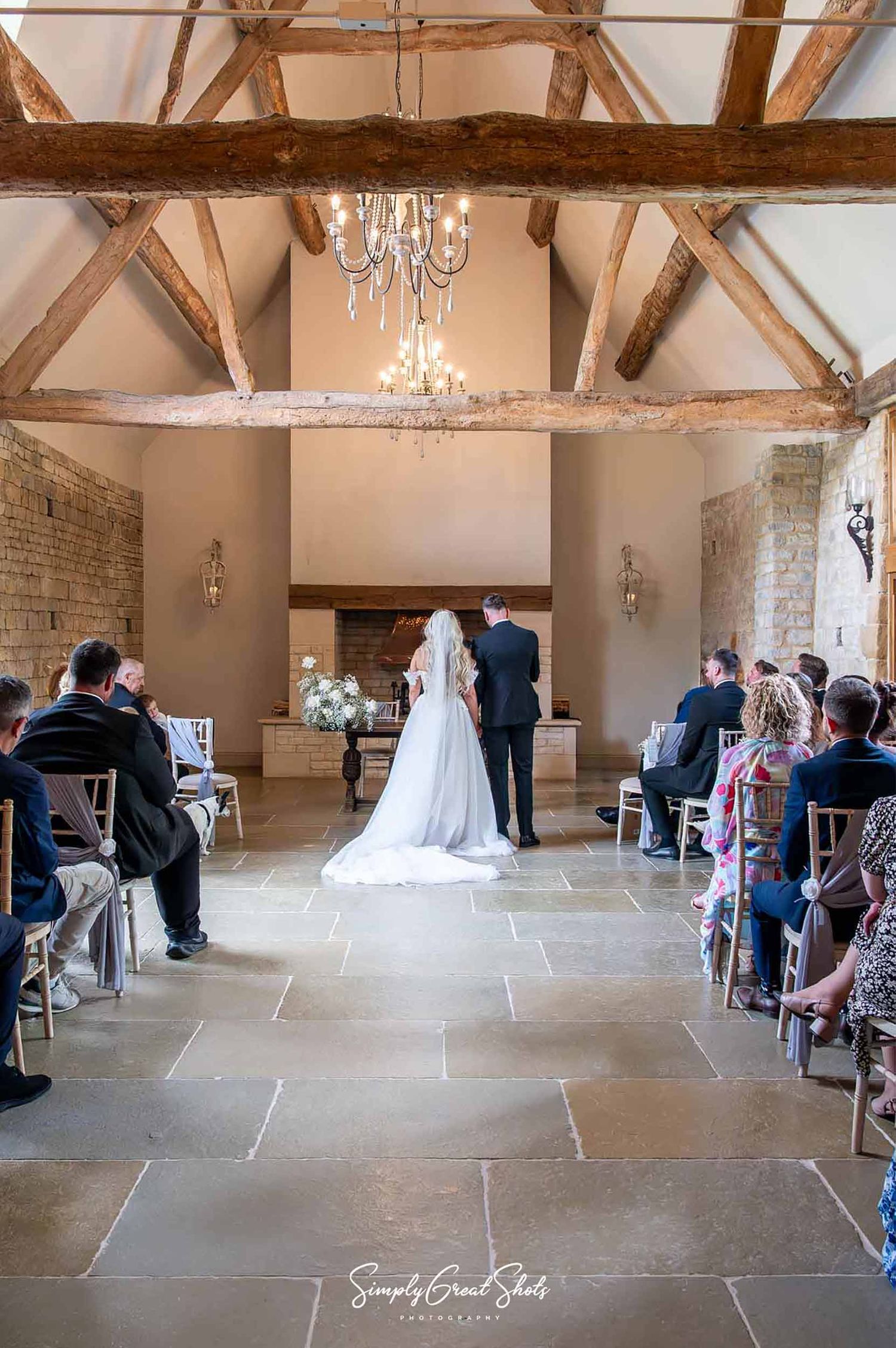 A father walks his daughter down the aisle at Blackwell Grange Wedding Venue. Complete with exposed wooden beams and elegant chandeliers.