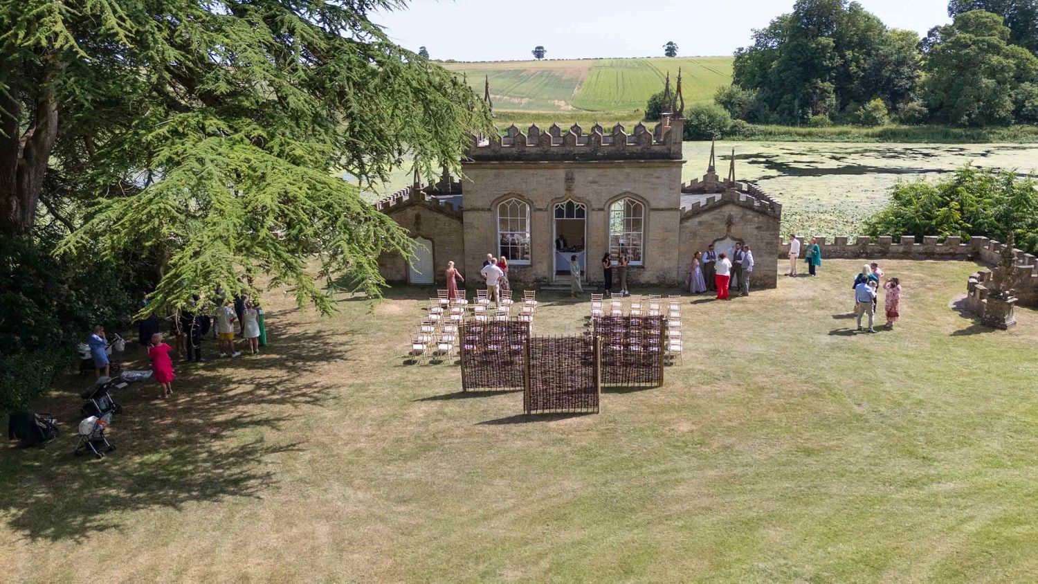 Fort Henry, an outdoor wedding venue with wooden chairs arranged on grass in front of a stone building with castle-like architecture.