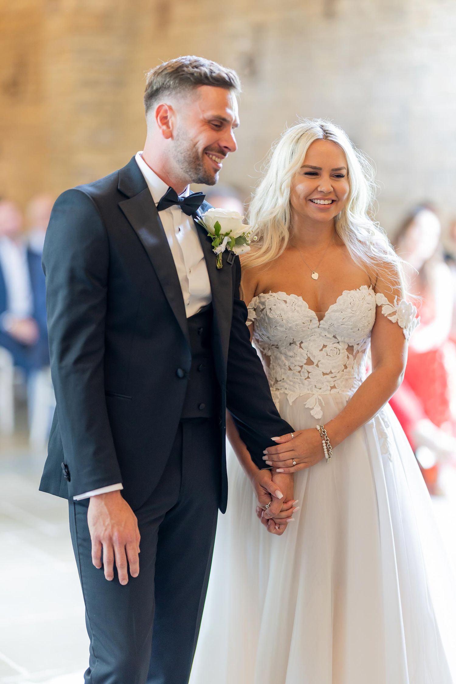A couple share a joyful moment on their wedding day at Blackwell Grange. The bride is wearing a white lace gown and the groom a black tuxedo