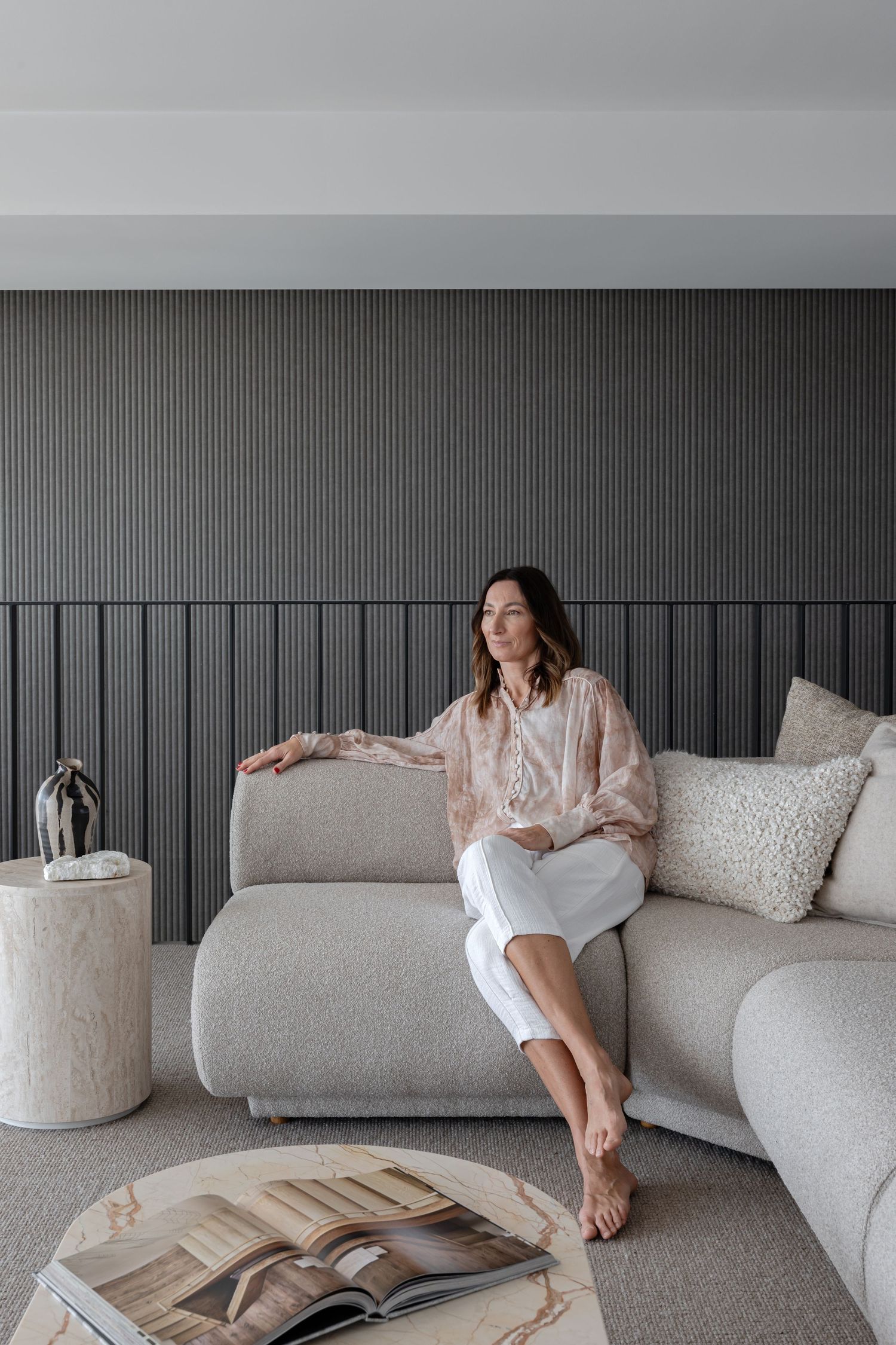 Minimalist living room with grey wall paneling and comfortable sectional sofa.