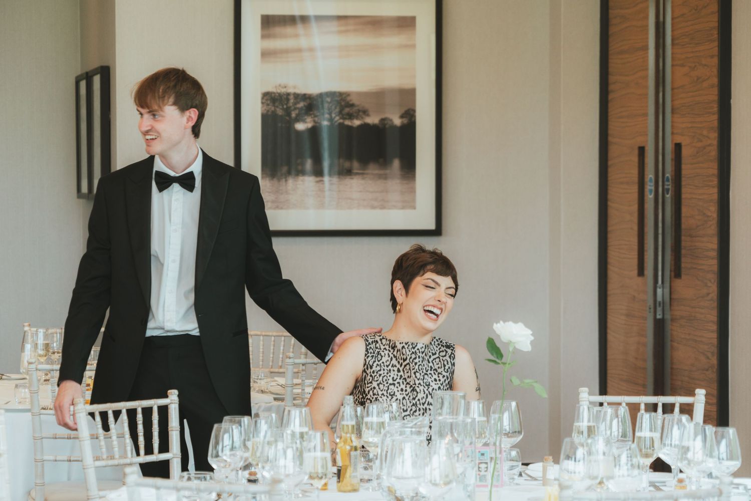 Formal dinner setup with elegant place settings and white chairs.