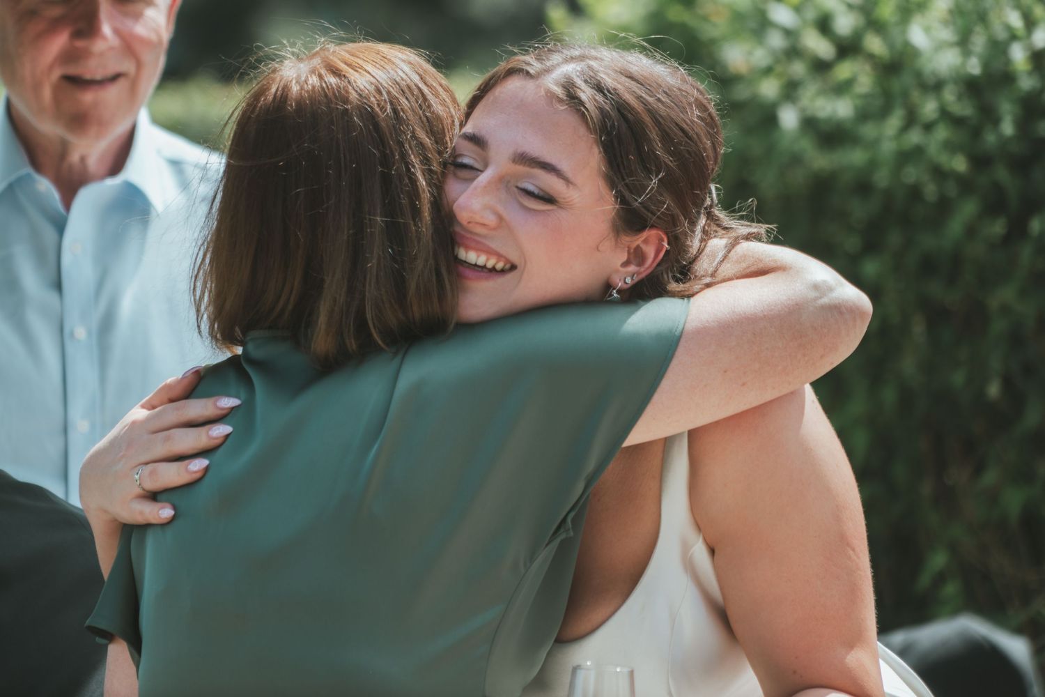 A joyful embrace shared during an outdoor wedding celebration.