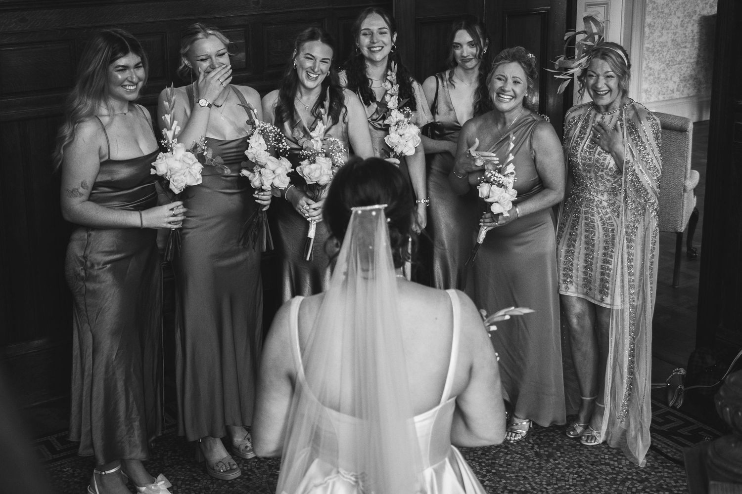 Group photo of wedding party members in coordinated purple dresses.