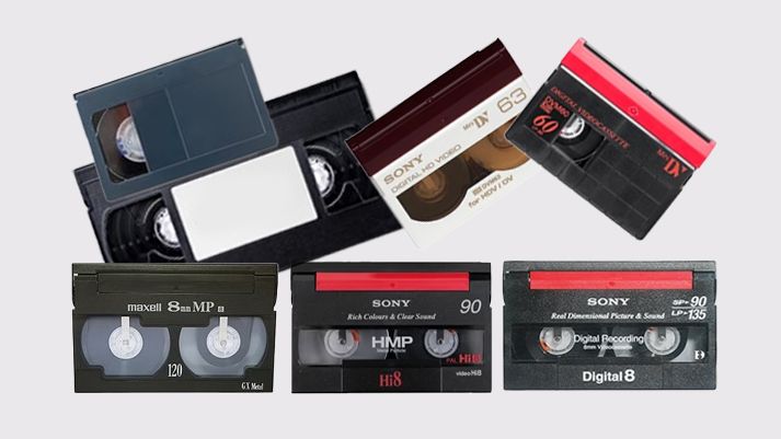 Collection of vintage VHS video cassette tapes and Betamax tapes arranged on white background.