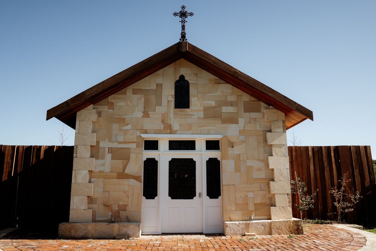 The Chapel Farm Estates stone church building with crosses and religious architectural elements set against a blue sky background.