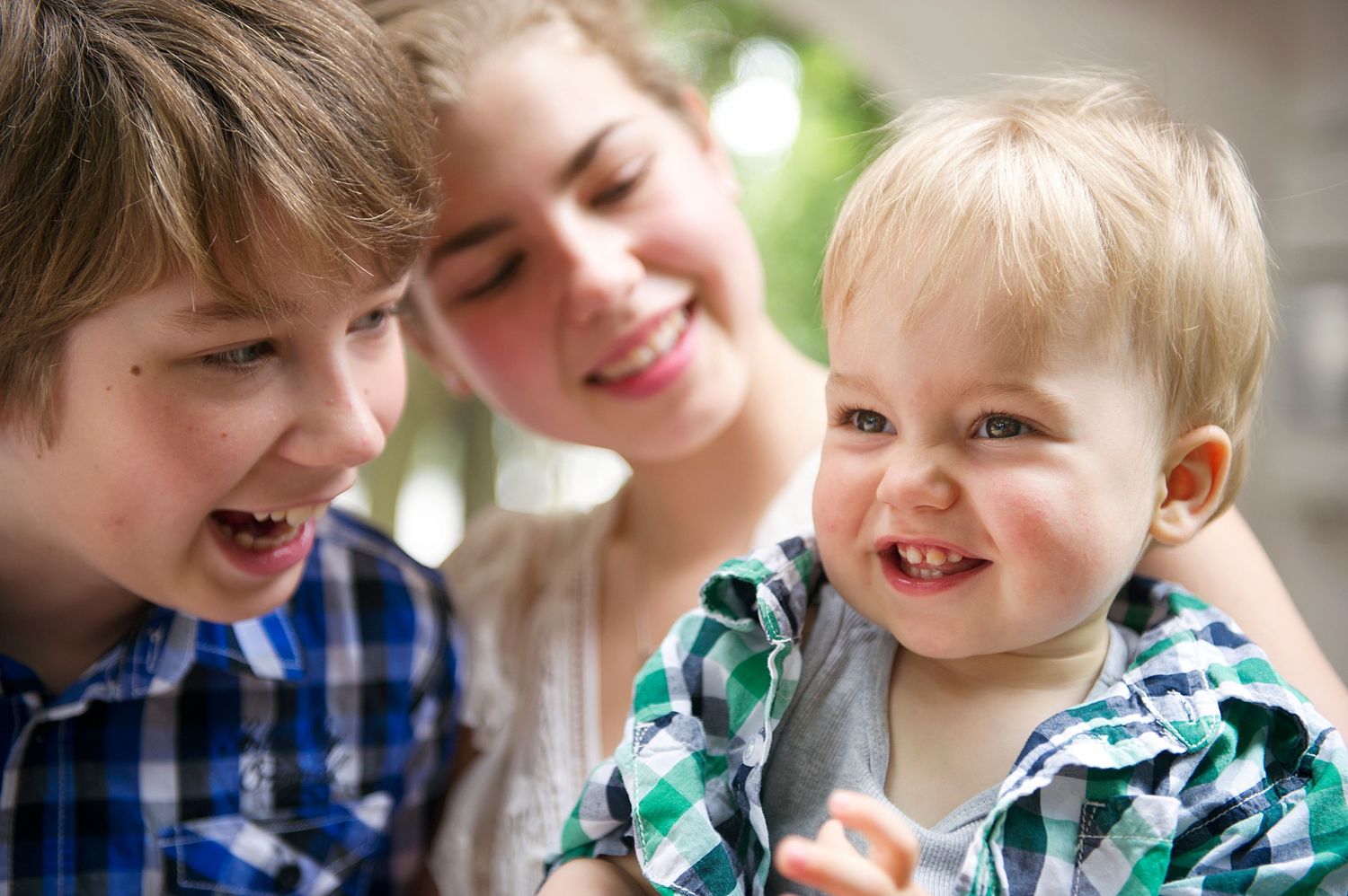 A close-up moment of shared joy and laughter between siblings. Family photography captured by Phoebe Lee Photo in Toronto, Ontario.