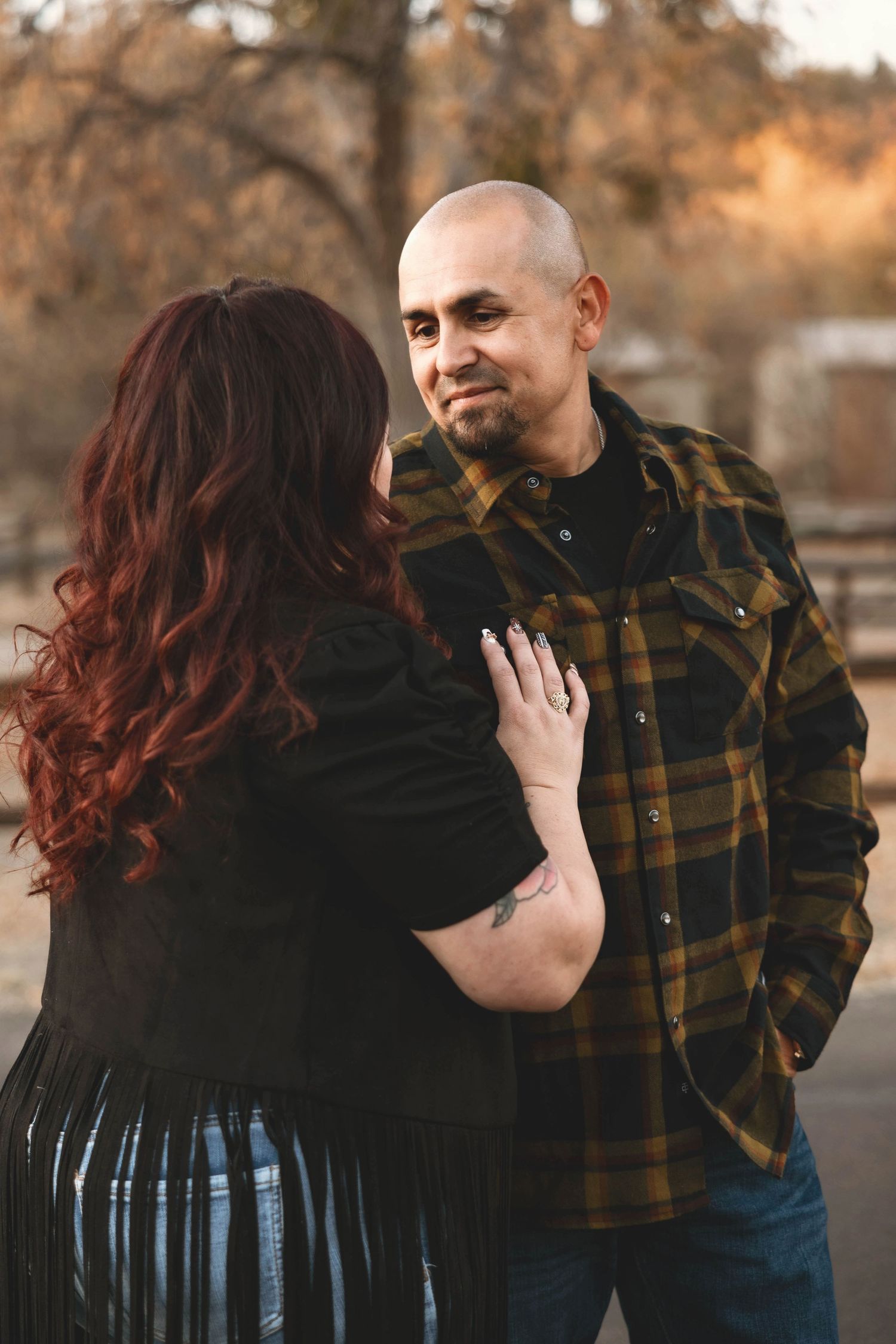 Couple in casual wear sharing tender moment during outdoor photo session.