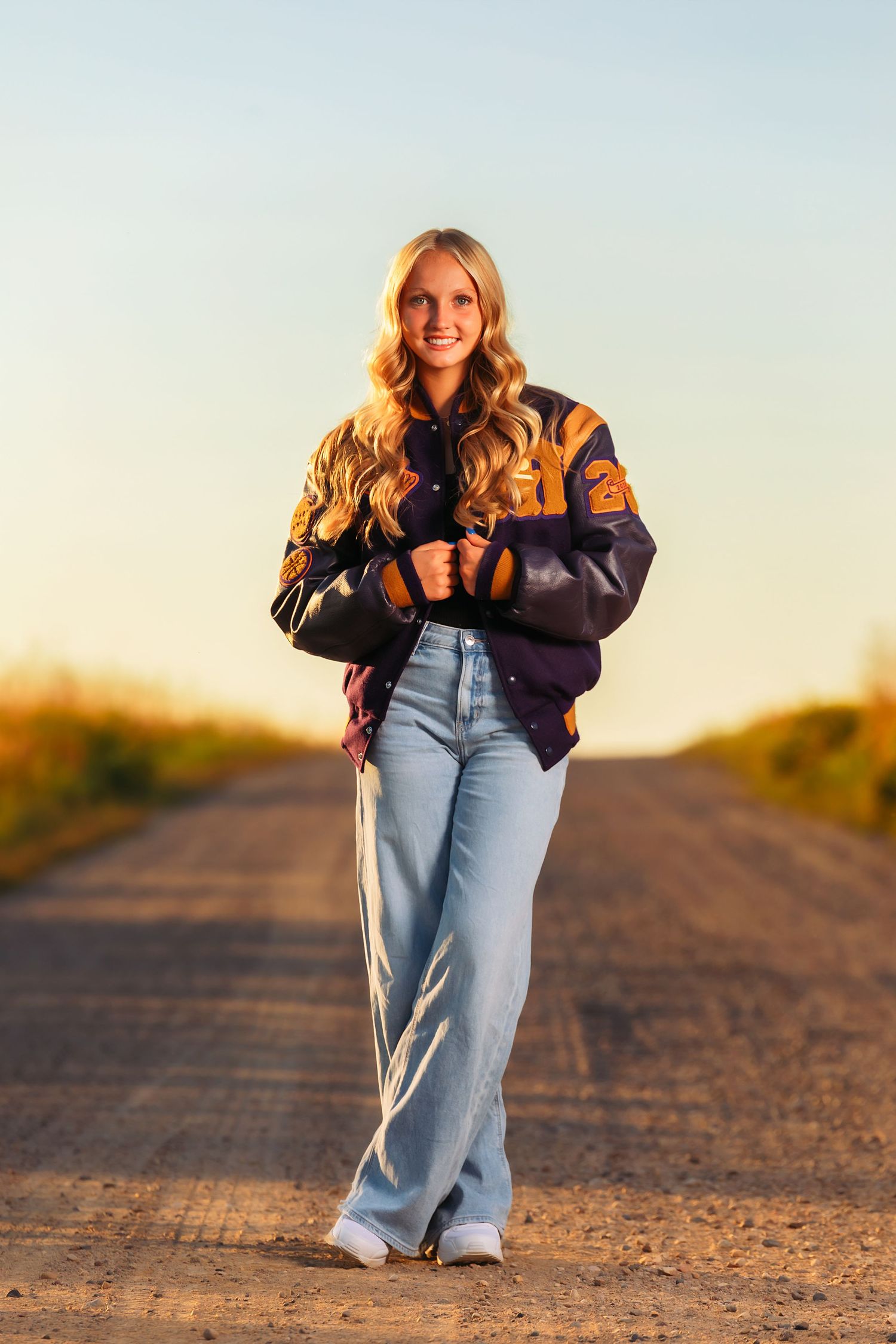 A casual photoshoot on a dirt path during golden hour sunset.