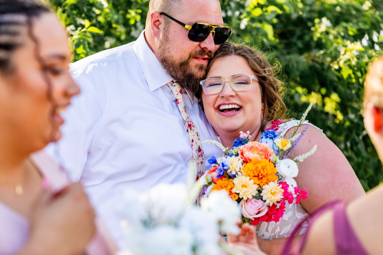 Candid moment of laughter during outdoor wedding festivities.
