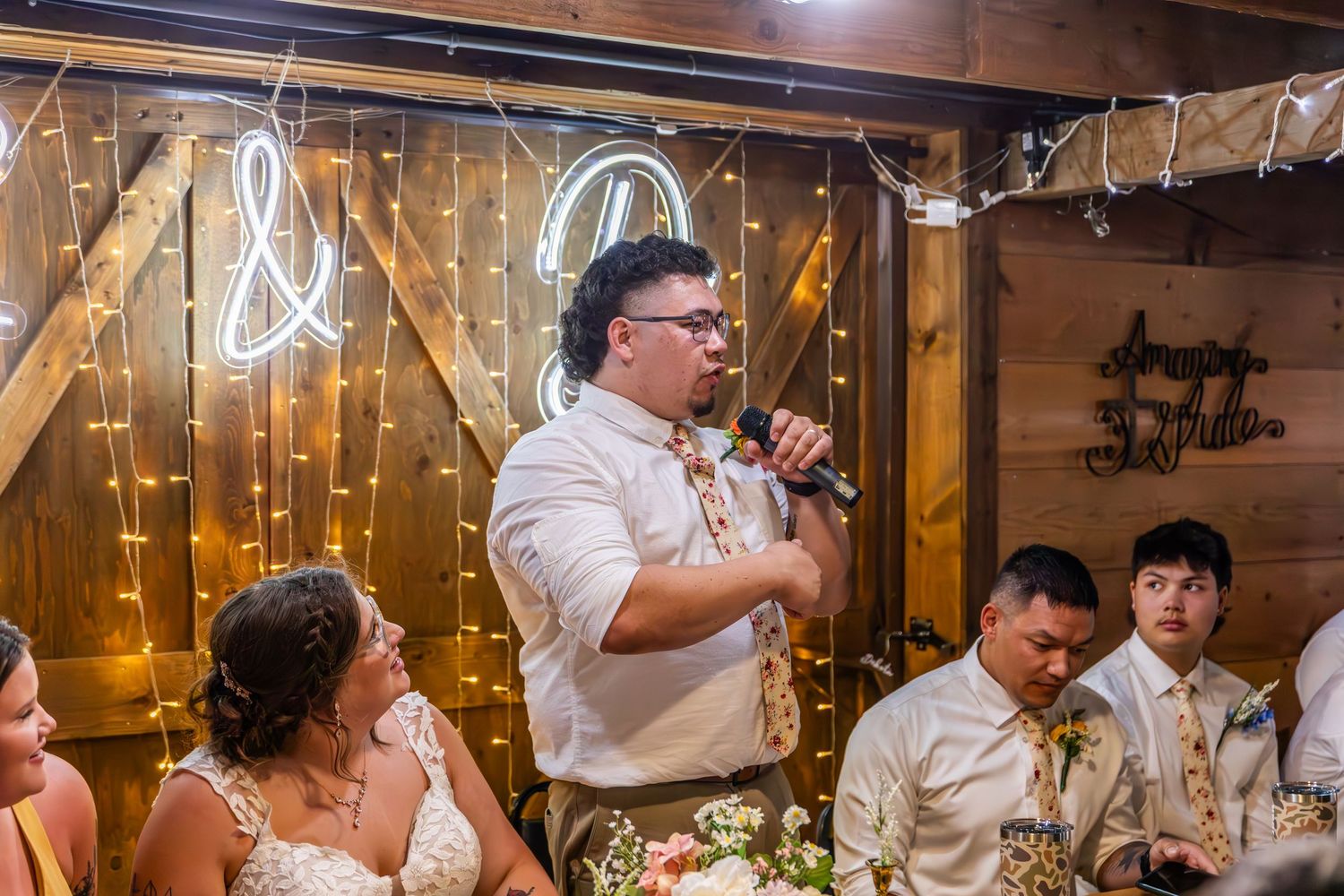 Rustic barn reception with twinkling lights and wooden decor creating a romantic atmosphere.