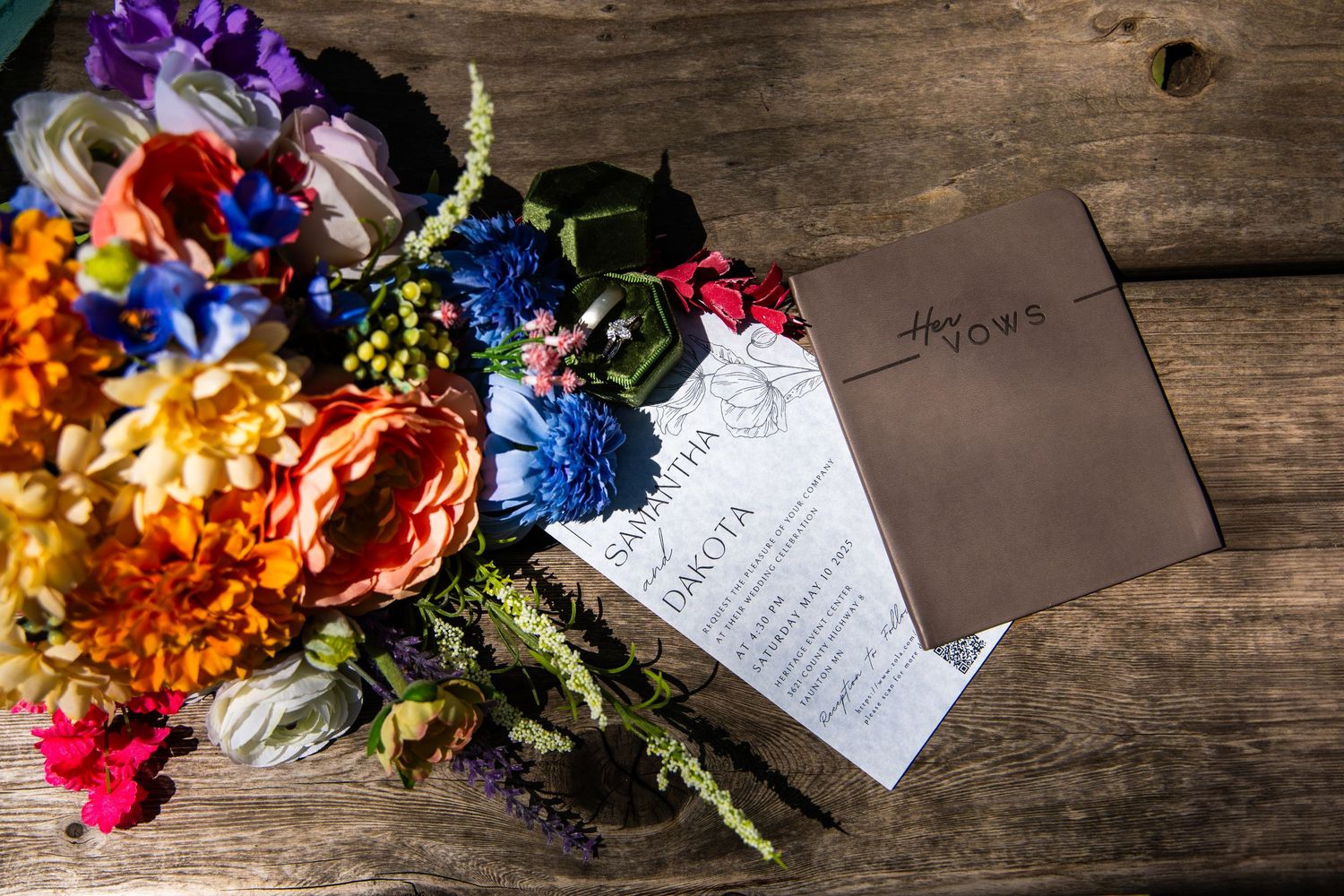 Bright floral bouquets with name cards artfully arranged on rustic wooden boards for a wedding.