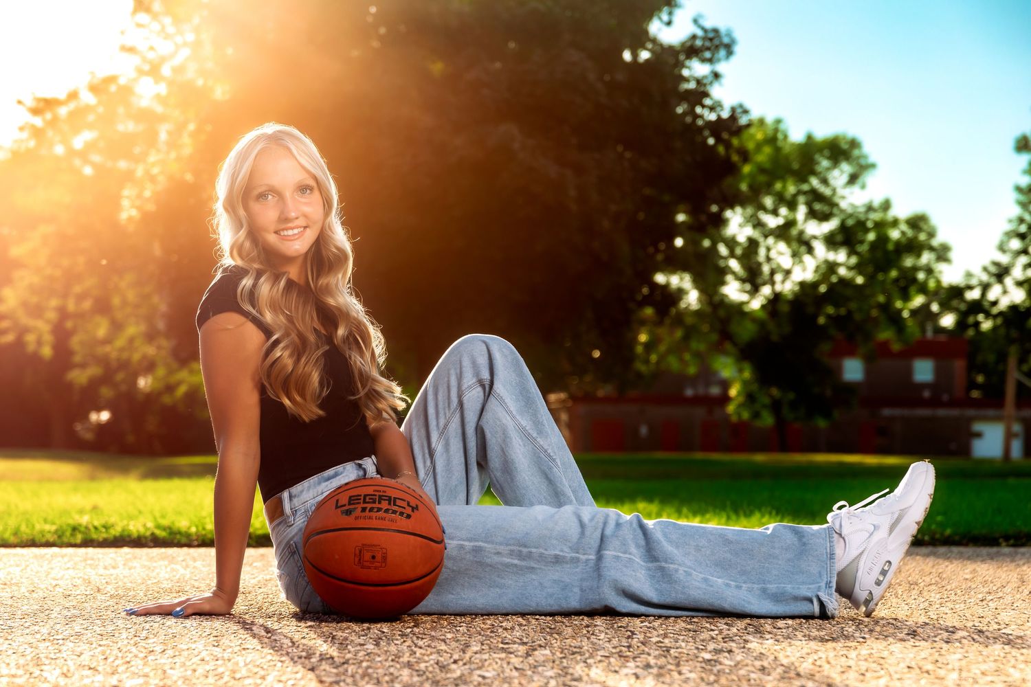 Sports portrait with basketball on outdoor concrete during sunset.