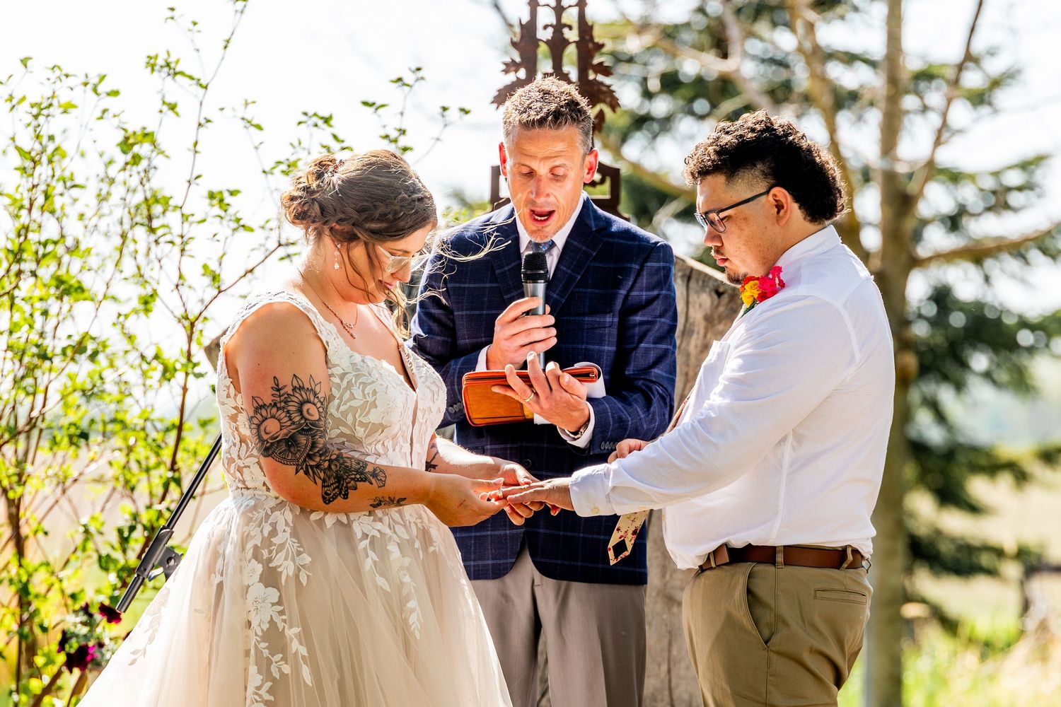 Intimate wedding ceremony moment as couple exchanges rings on outdoor platform.