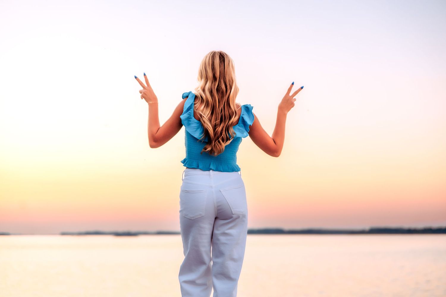 Silhouette pose against sunset sky in casual attire.