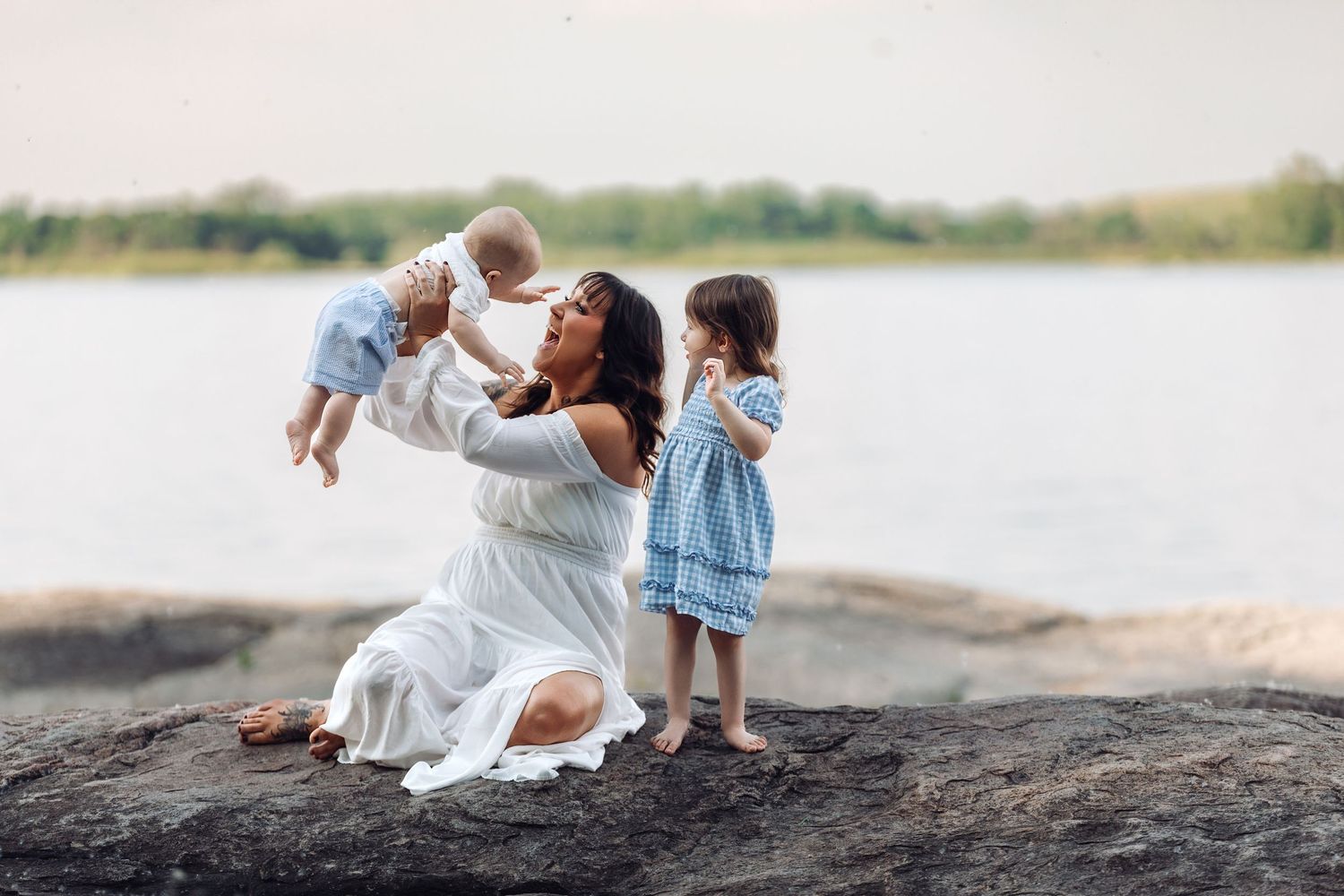 A tender moment shared at the water's edge with a flowing white dress against a serene lake backdrop at Lac qui Parle State Park.