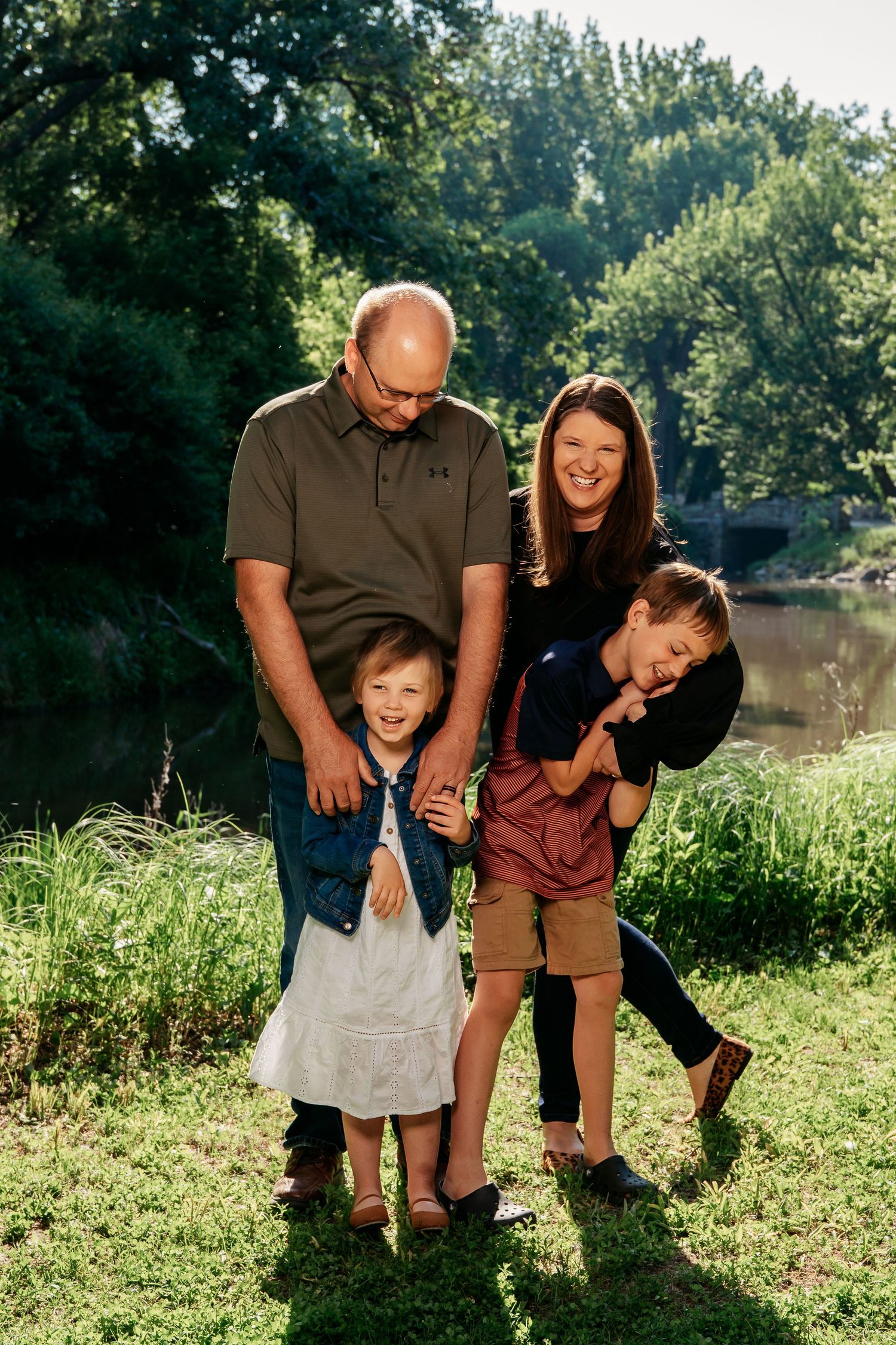 Candid family moment captured outdoors showing playful interaction in nature setting.