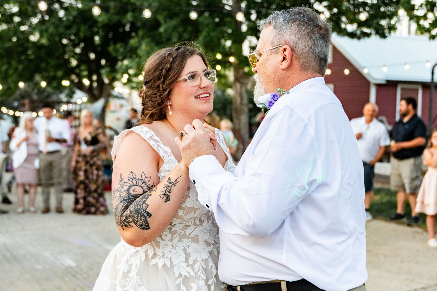 Wedding couple dancing and celebrating with joy during outdoor barn reception.