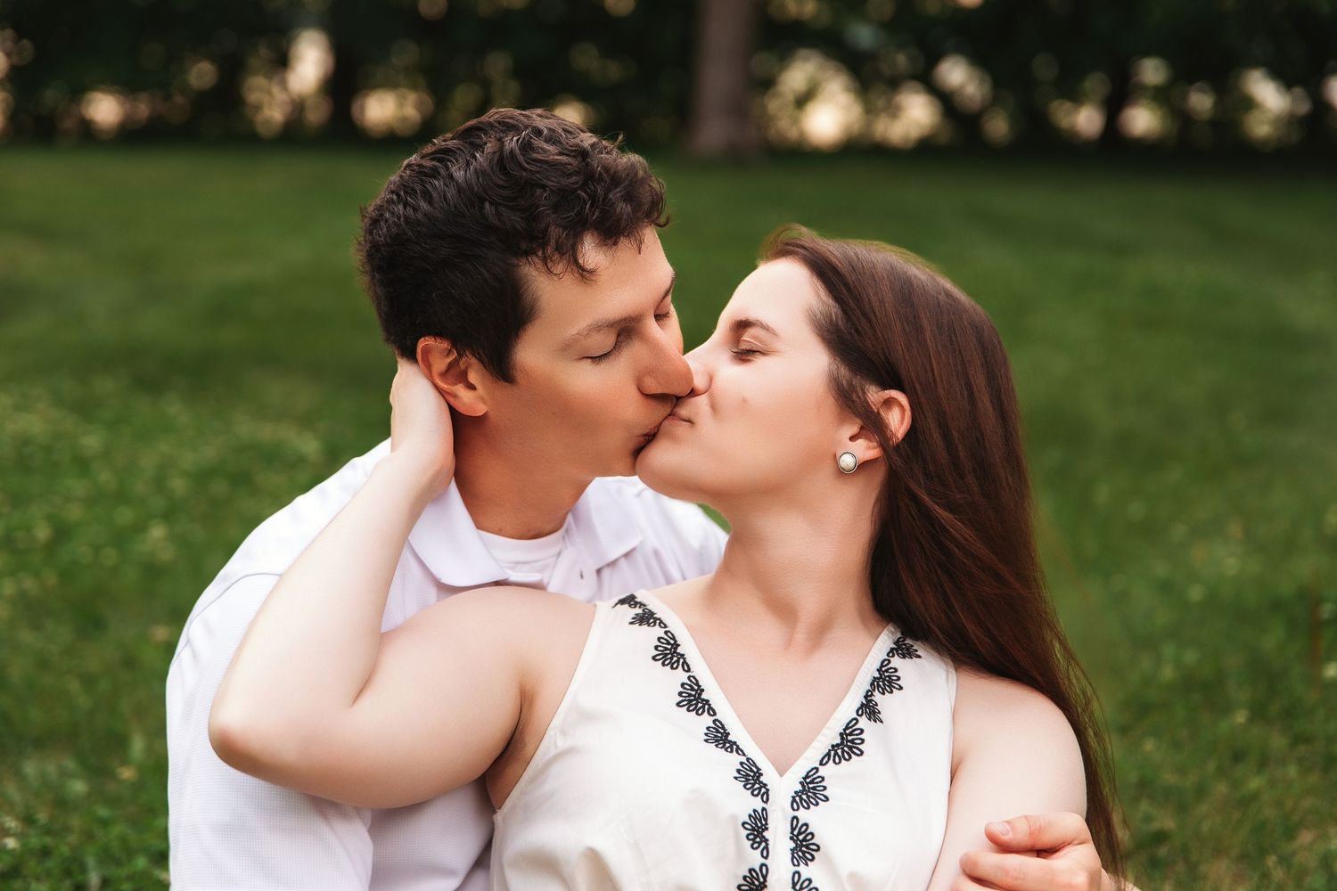 Intimate outdoor portrait sequence showing tender moments against a green grassy background.