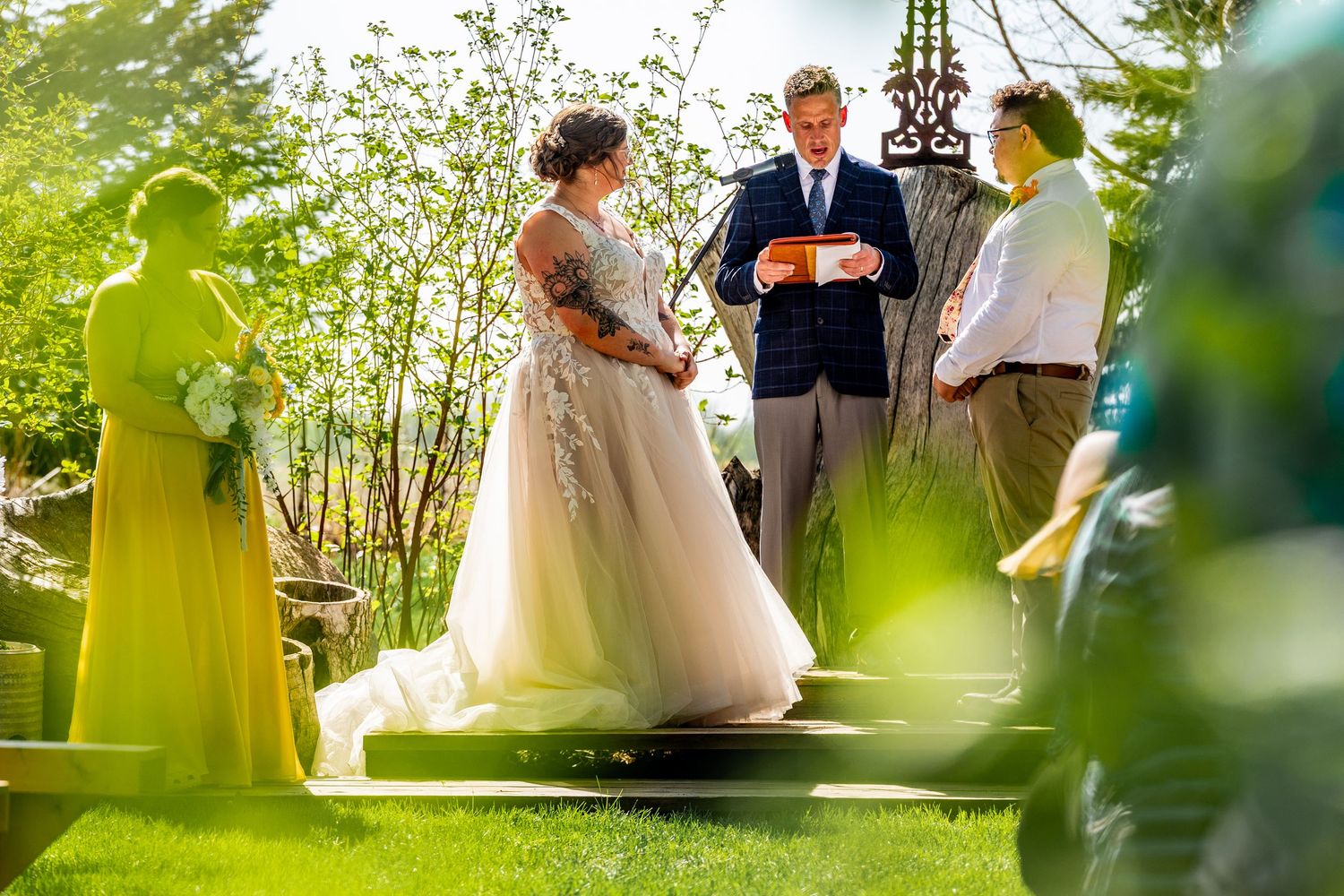 Intimate garden wedding ceremony surrounded by lush greenery and natural lighting.