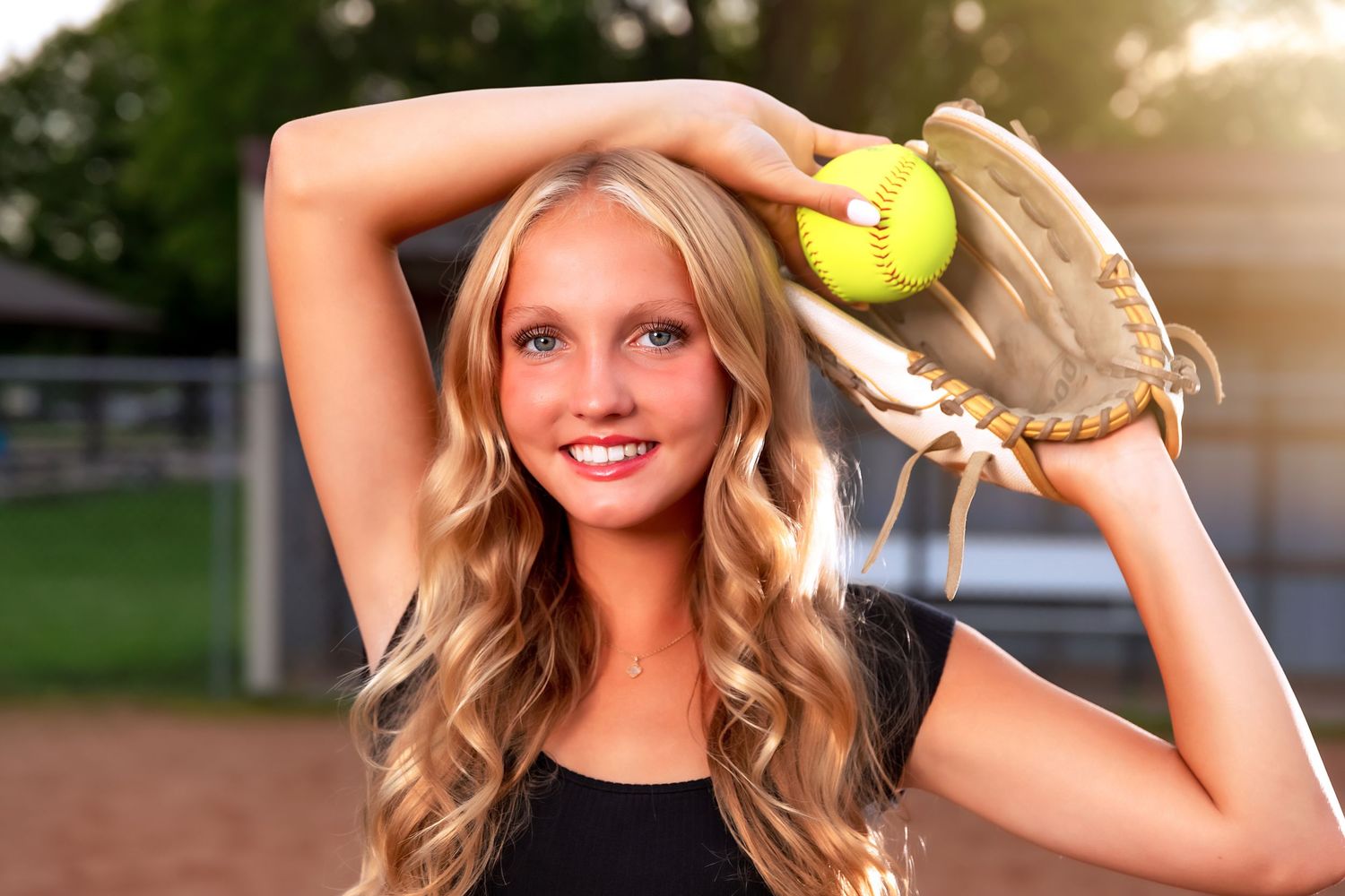 A tennis court scene with tennis balls and racquet during sunset.