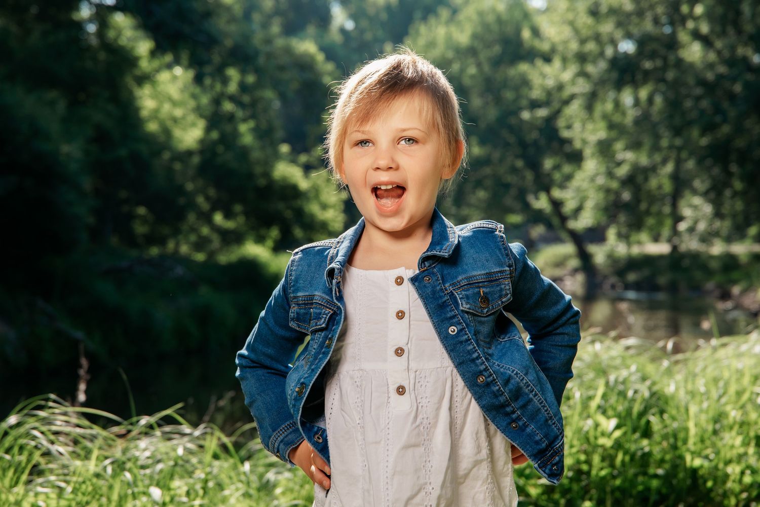 A child in denim and white plays outdoors in a sunny garden setting, showing joyful expressions and playful movement.