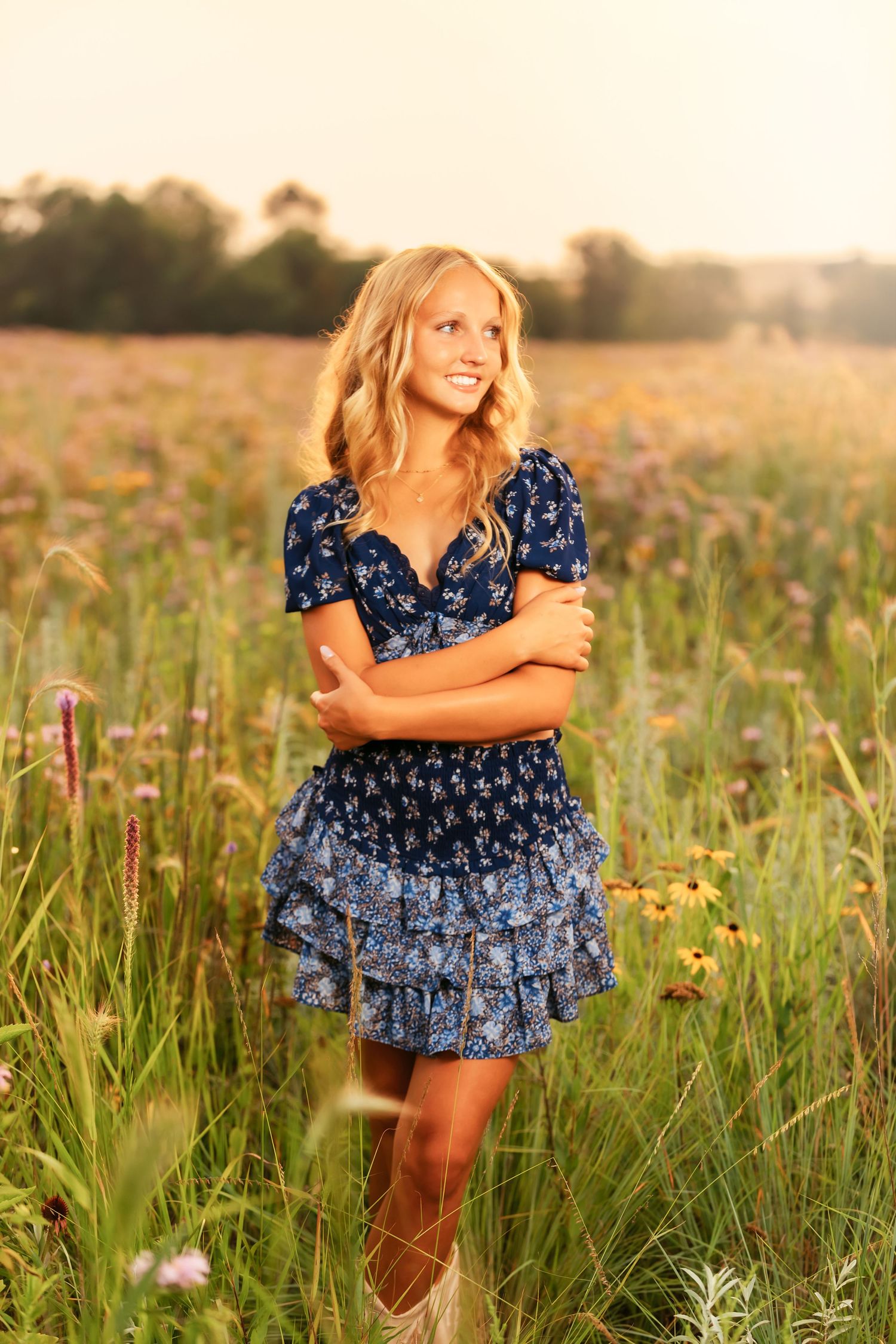 A blue floral dress twirls through a summer meadow filled with wildflowers at golden hour.