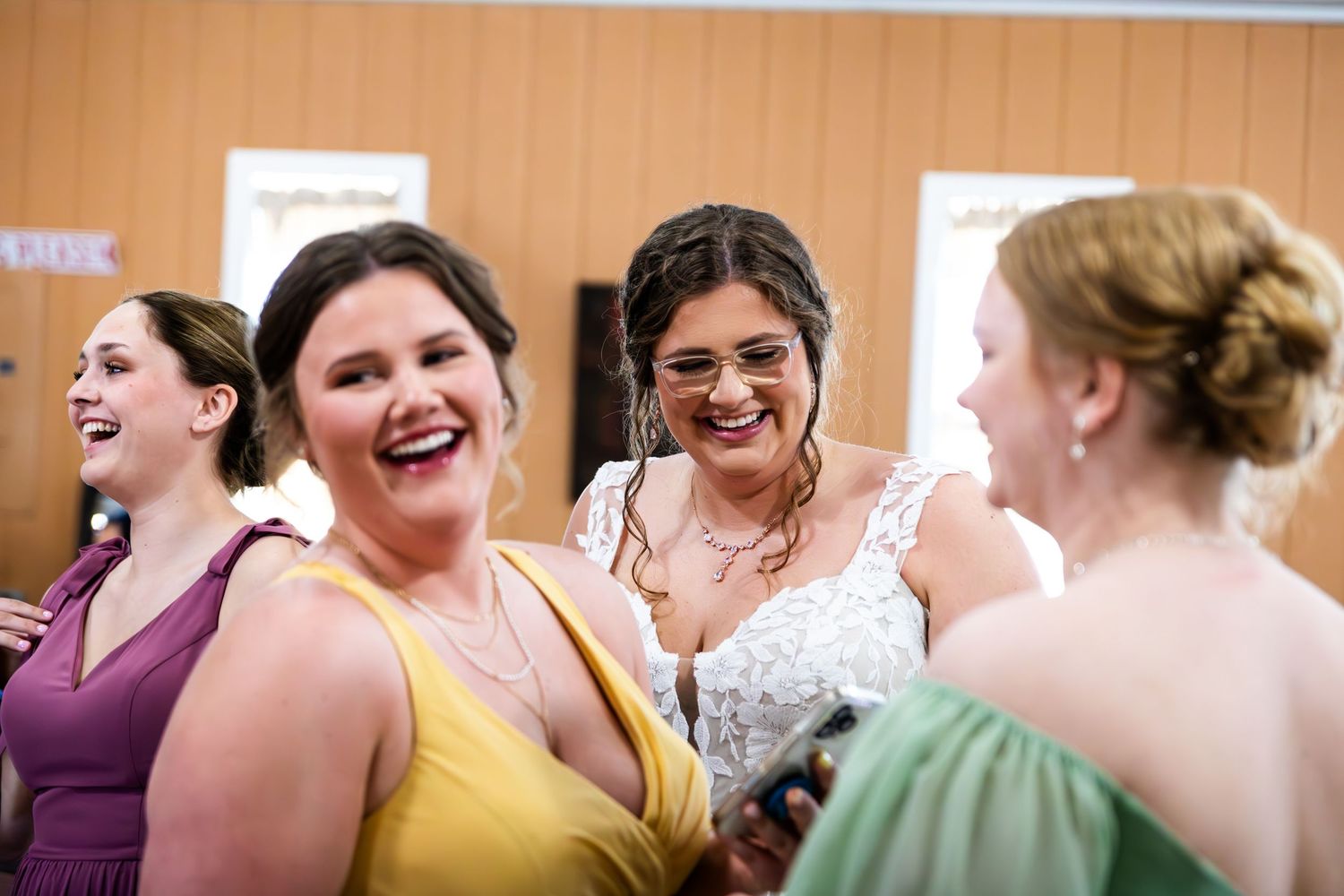 A group shares joyful laughter while wearing formal attire at a special event.