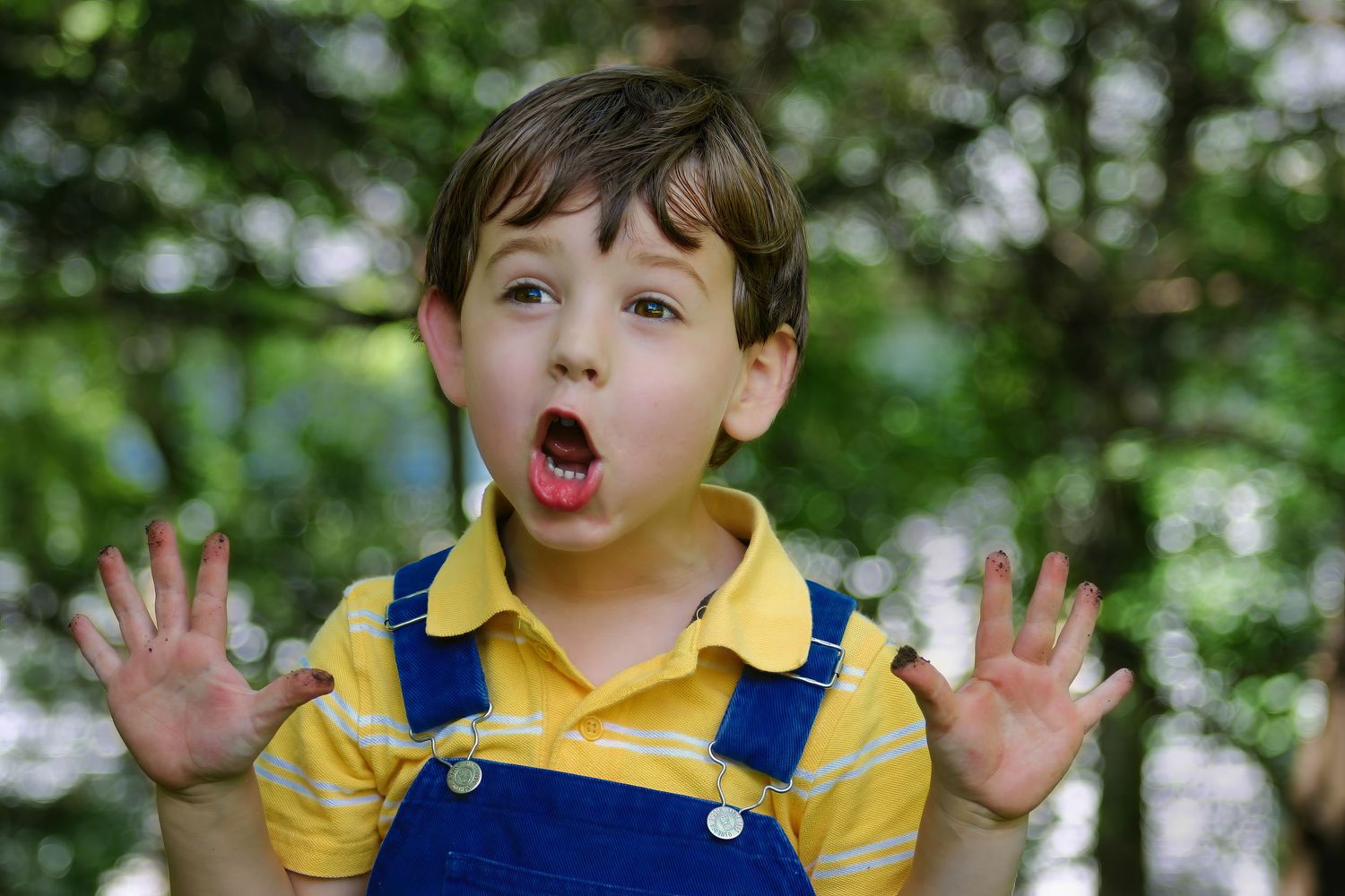 Candid kids portrait in Pensacola, FL—funny moment with dirty hands raised, mouth open in surprise. “Dirty Dirt” by Photography by Rachel.