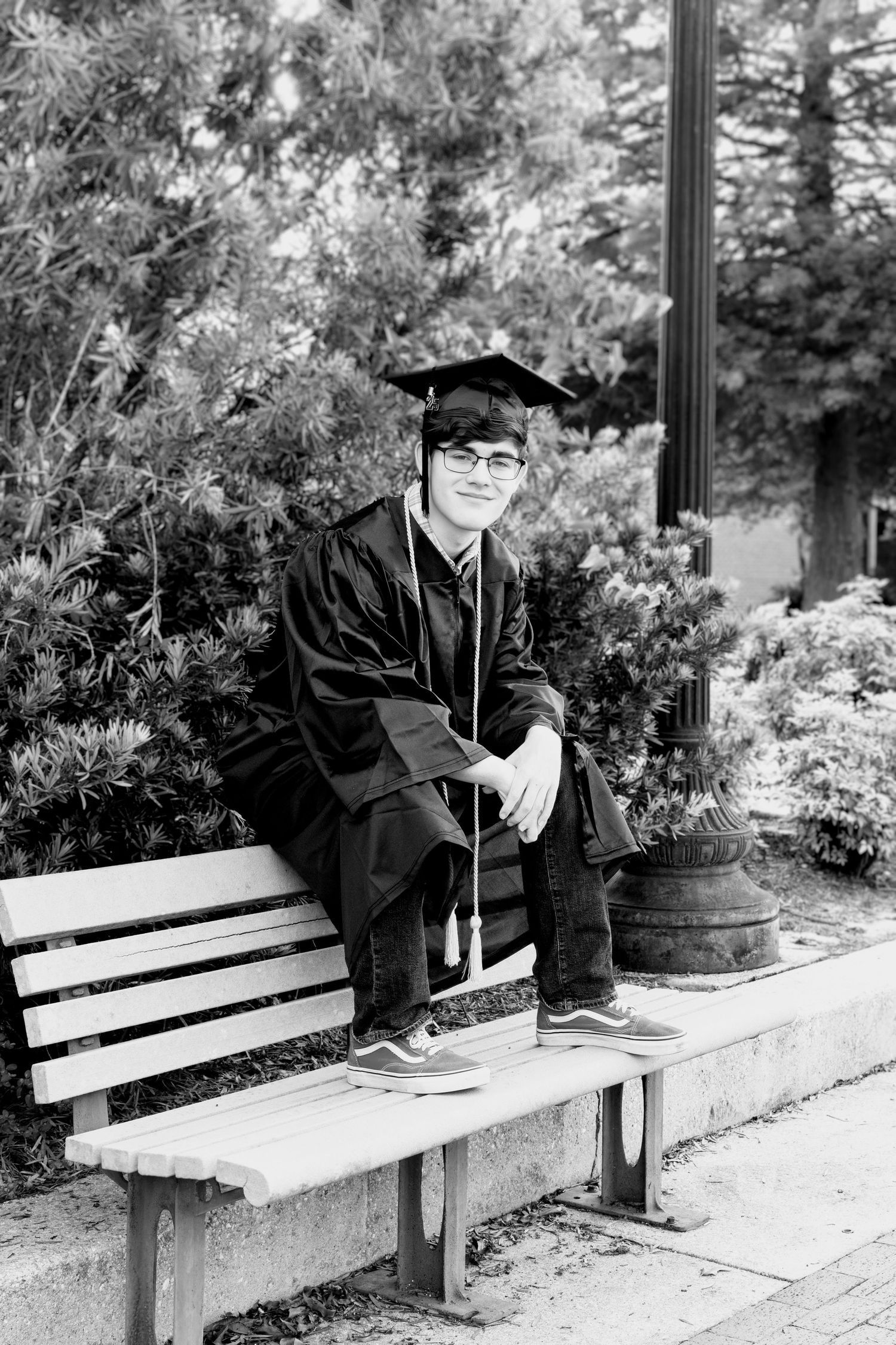 Black and white senior portrait of a male graduate in cap & gown at Milton Riverwalk, Florida—natural, timeless, and authentic.