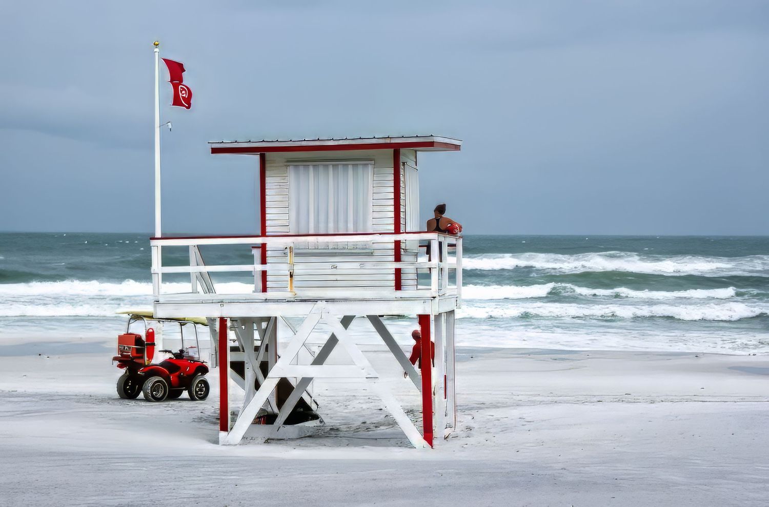 Fine art photo, Pensacola Beach—stormy skies, white sand, raised lifeguard station with bold red accents, flag & rescue 4 wheeler
