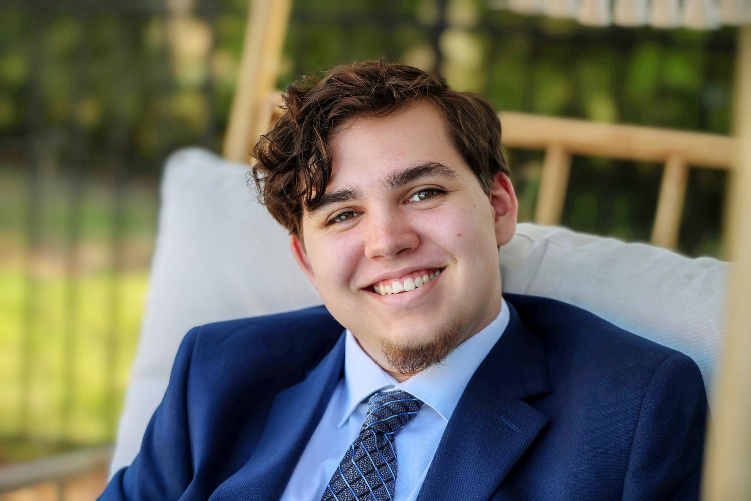 Candid senior portrait, smiling teen boy in blue suit, Pace FL—handsome, casual, expressive with a spark of mischief.
