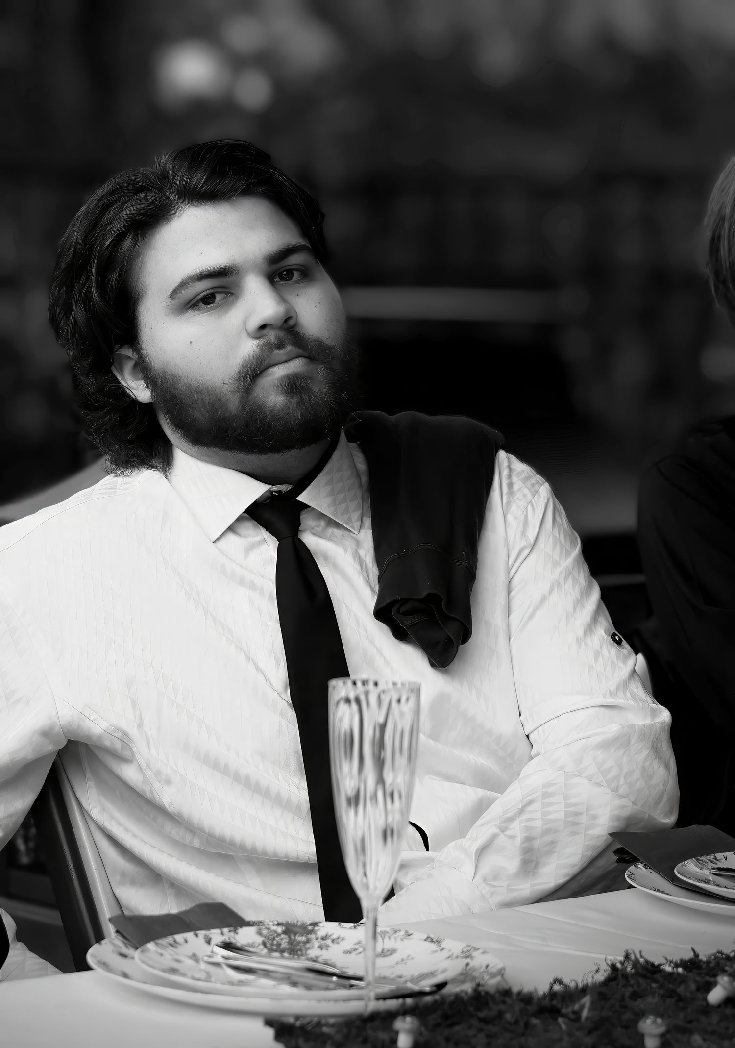 Candid black and white portrait of a bearded senior male at a prom dinner event in Pace, FL—natural light by Photography by Rachel.